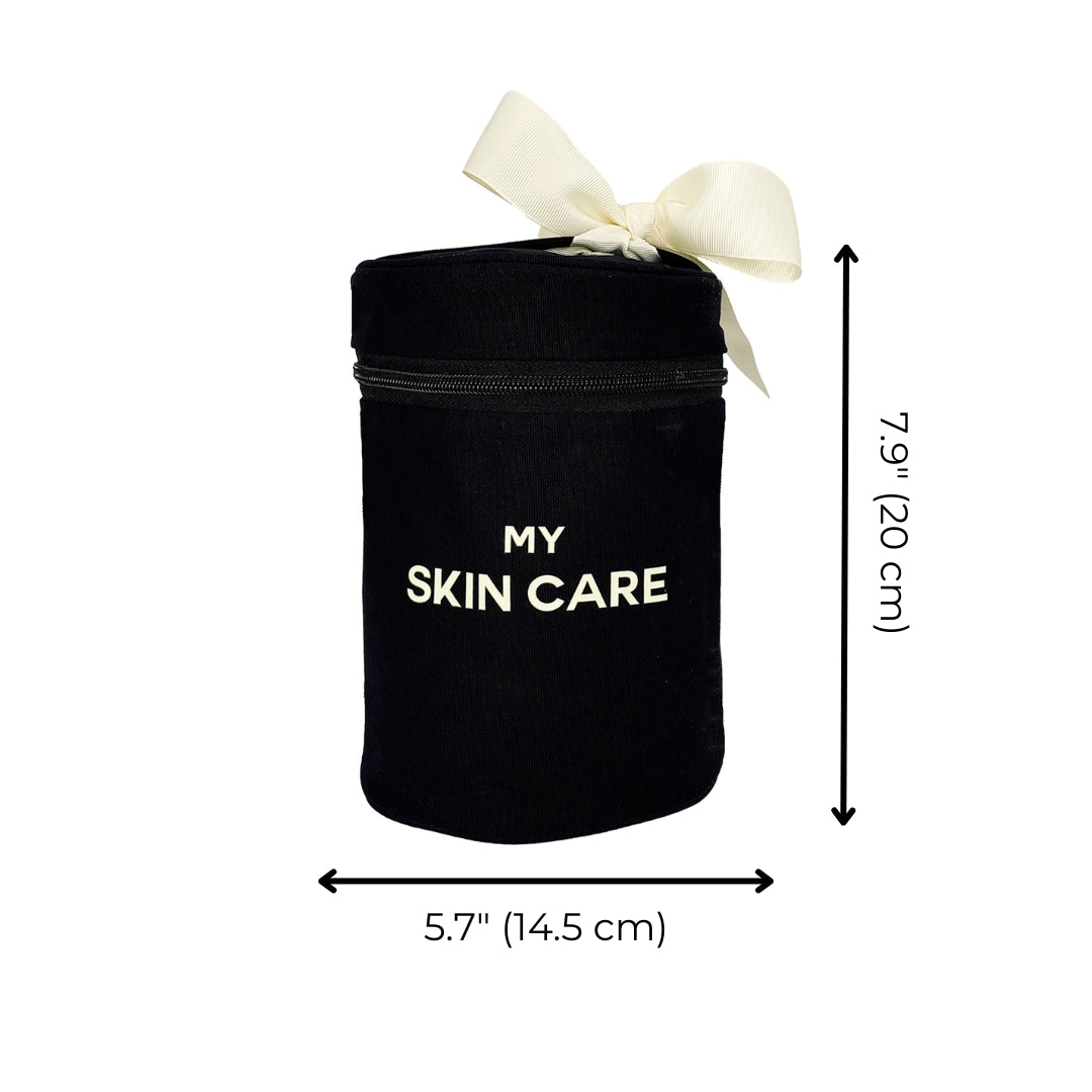 Bag-all Round Skin Care Case with Handle in black cotton, featuring cream bow accent, 'MY SKIN CARE' text, secure zipper closure, 7.9 inches tall by 5.7 inches wide