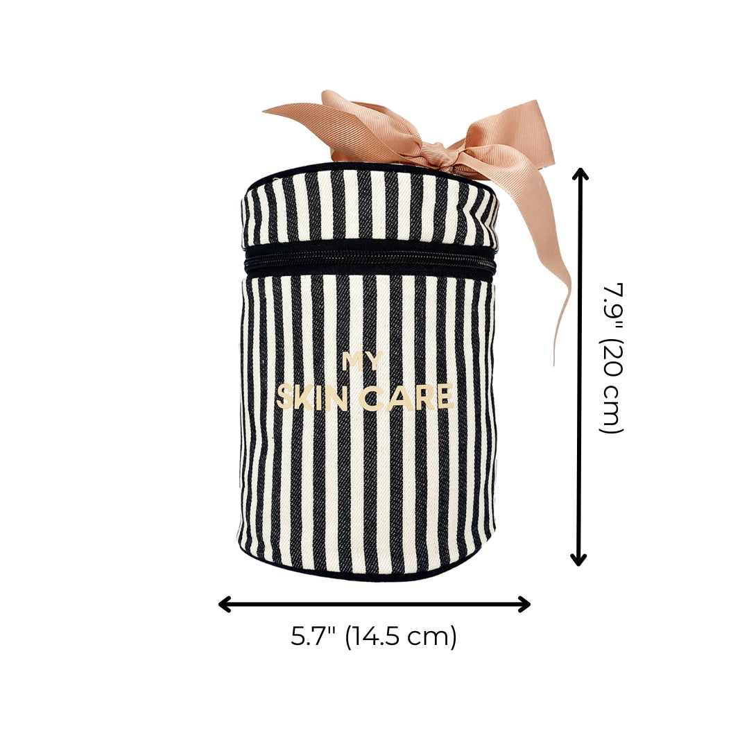 Bag-all Round Skin Care Case with Handle in black and white stripes, pink bow accent, gold lettering, featuring laminated interior and organized compartments, measuring 7.9 x 5.7 inches