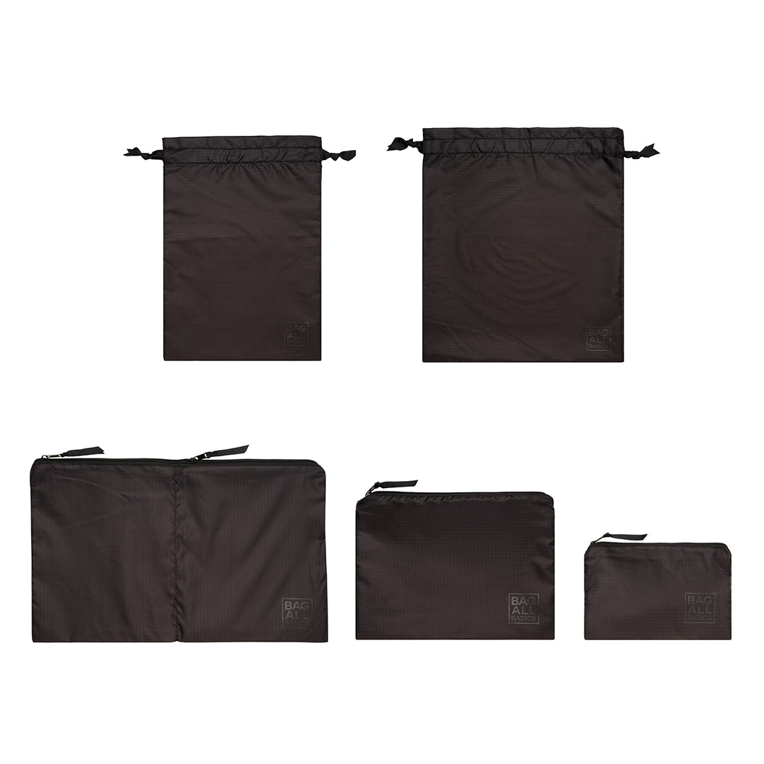 Bag-all Packing Bags Set in recycled nylon, featuring 5 black organizer bags in various sizes with drawstring and zipper closures, made from eco-friendly repurposed plastic bottles