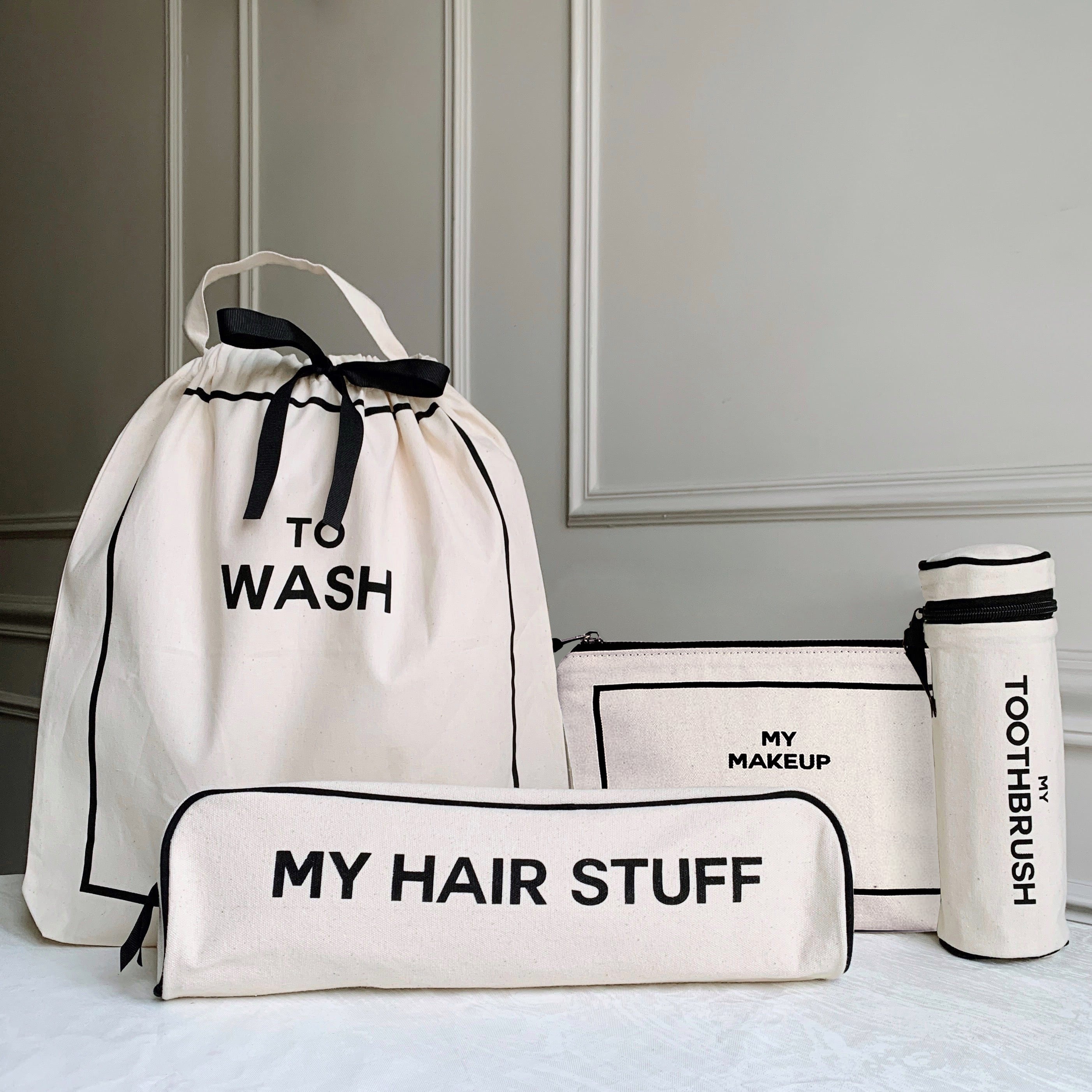 Bag-all Travel Set featuring To Wash bag, My Hair Stuff case, My Makeup pouch, and Toothbrush holder in white cotton with black trim and text labels