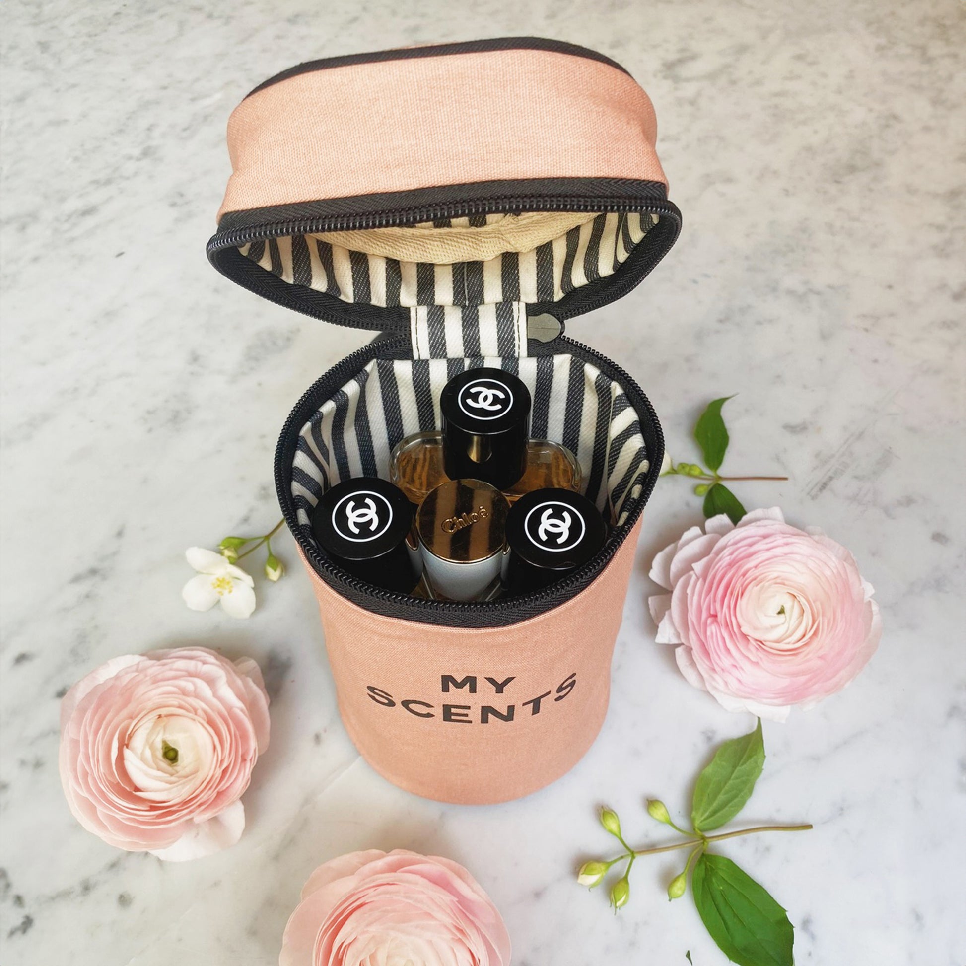 Bag-all Round My Scents Case in blush pink, featuring striped interior lining, secure elastic bands, cylindrical design for perfume storage and organization