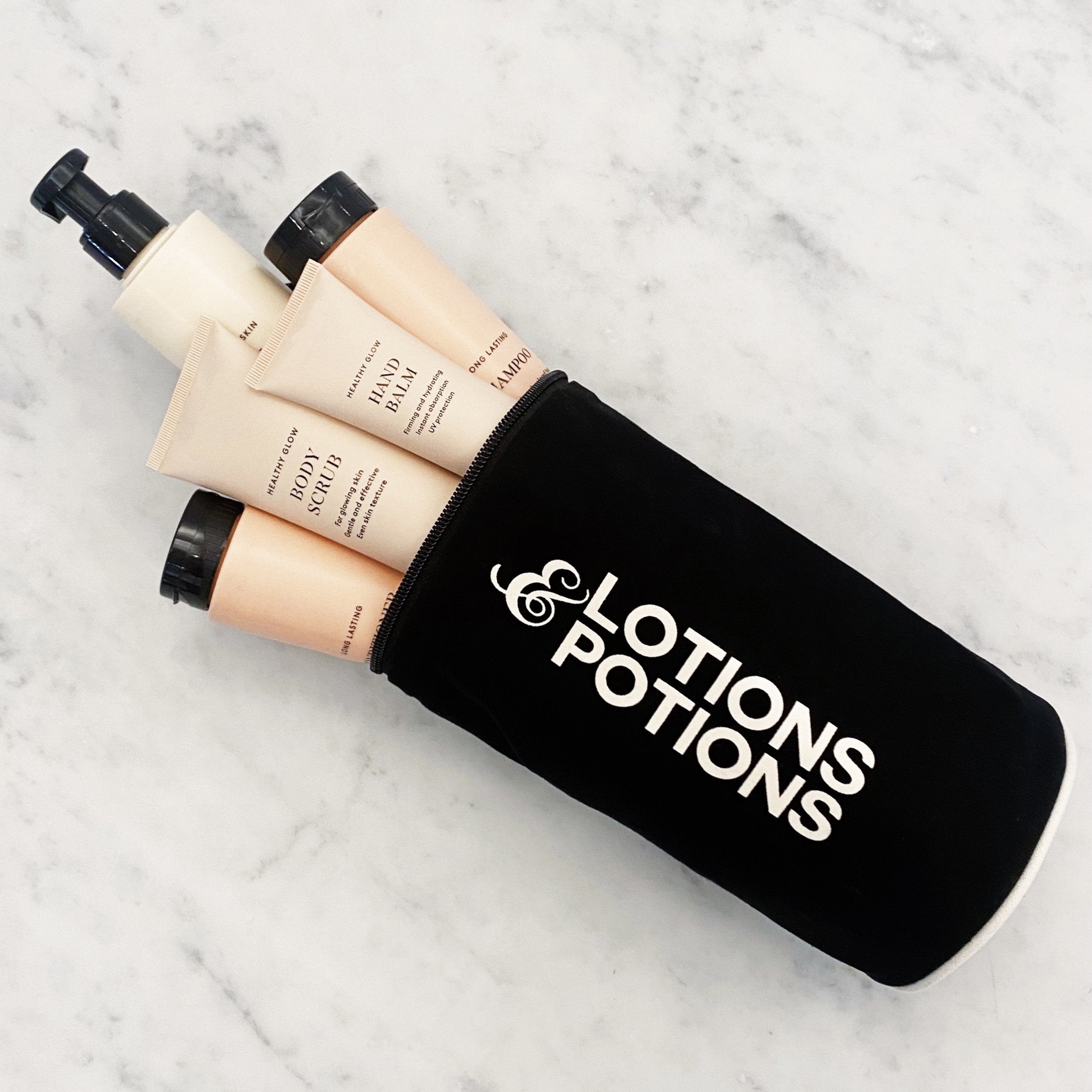 Bag-all black lotion and potions travel organizer pouch with skincare tubes on marble surface for spa lovers