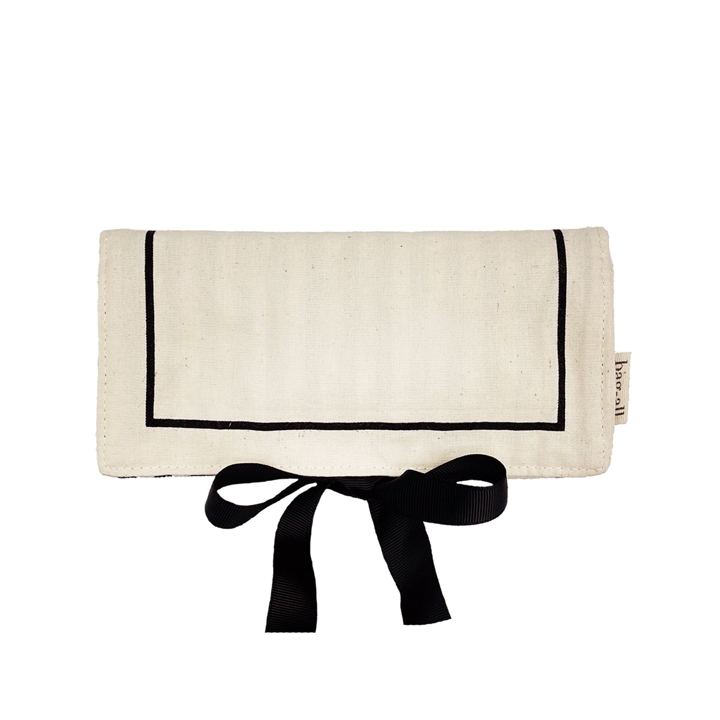 Bag-all Couture Jewelry Roll Medium in cream canvas with black border trim and elegant ribbon tie closure, perfect for organizing jewelry on the go