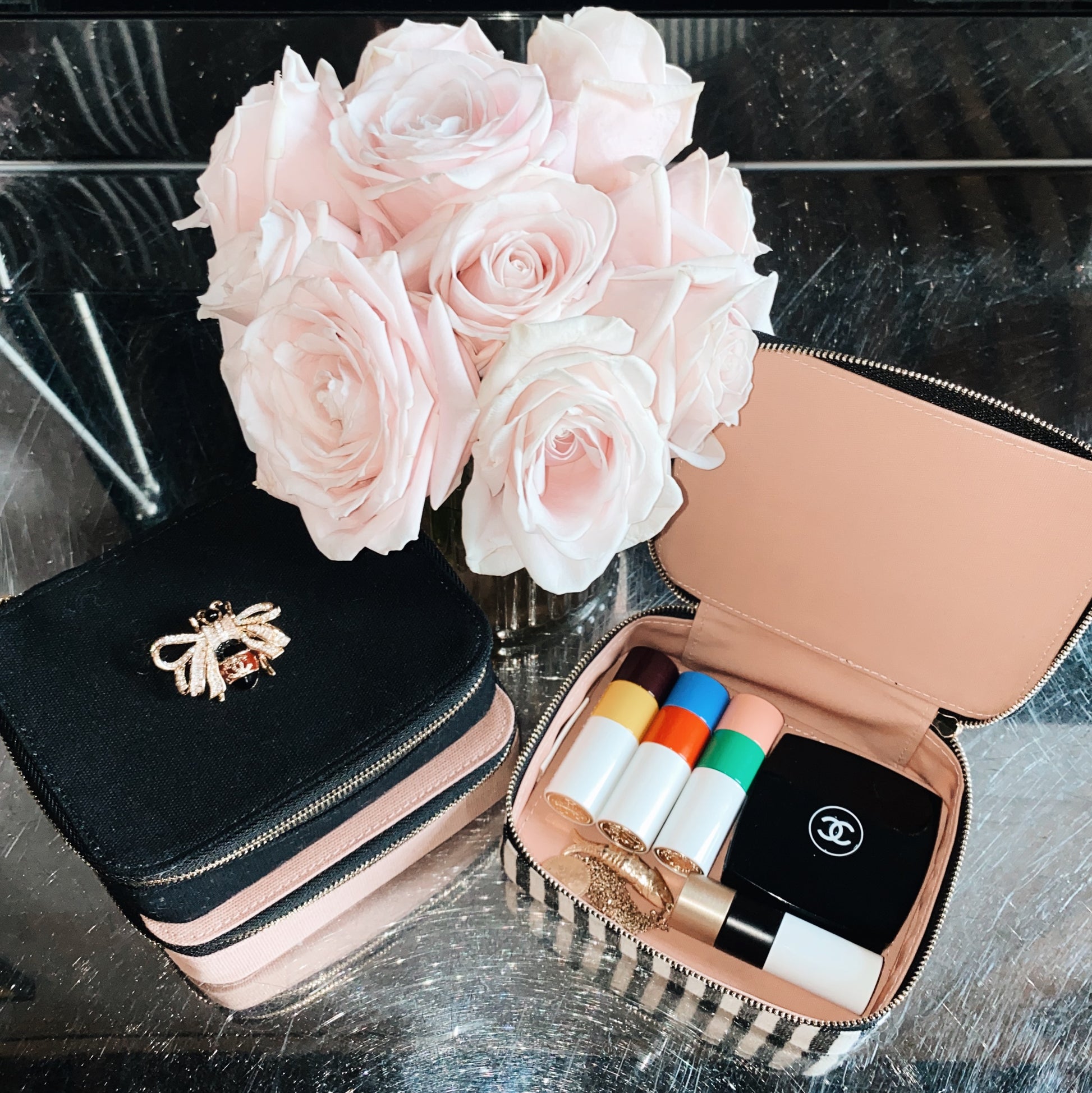 Bag-all Cosmetics/Trinket Box in striped design shown with pink roses and open to display makeup essentials, featuring gold zipper and stylish storage organization