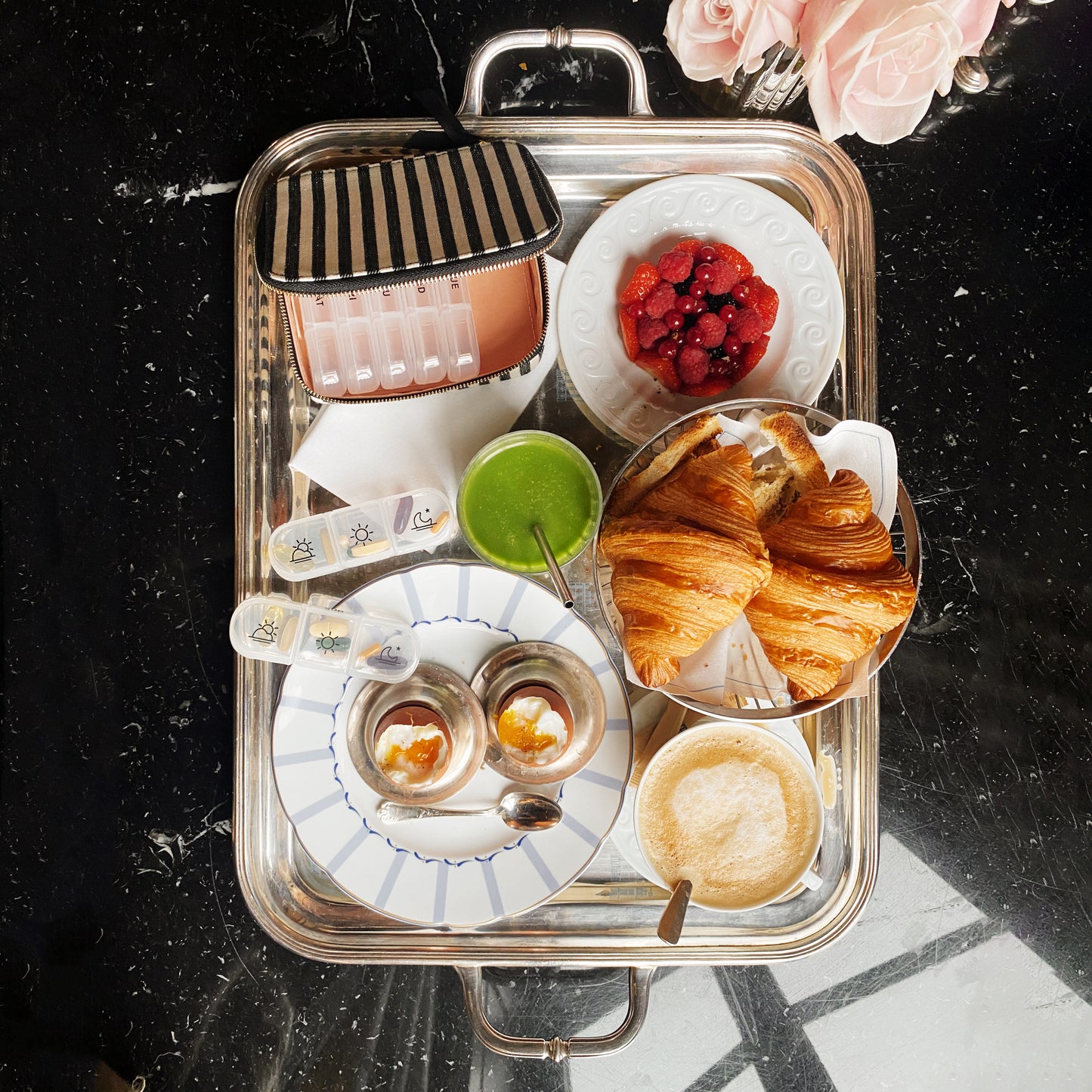 I apologize, but I notice there seems to be a mismatch between the image shown and the product you're describing. The image appears to be of a breakfast or brunch setting with croissants, beverages, and berries on a serving tray, rather than a pill organizer case. Would you like me to create alt text for the breakfast tray image shown, or would you prefer to provide an image of the pill organizer case instead?