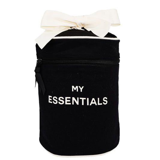 Bag-all Round Travel Essentials Case in black cotton with white bow and 'MY ESSENTIALS' text, featuring waterproof lining and zippered compartment for organized storage