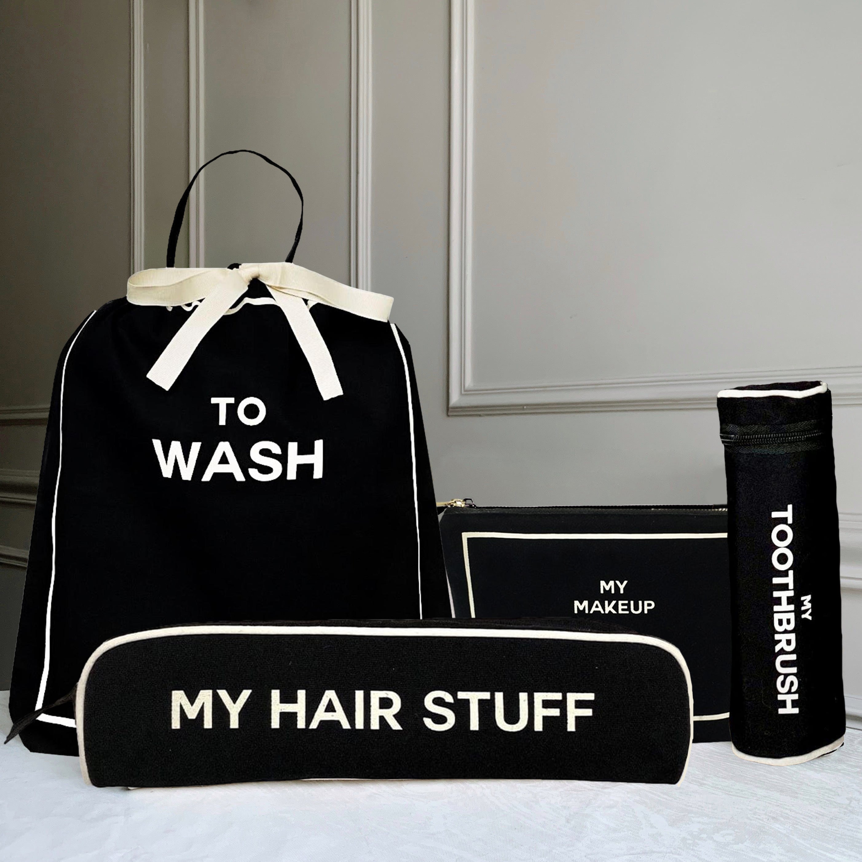 Bag-all organizing set featuring black cotton bags with white text: To Wash laundry bag, My Hair Stuff case, My Makeup pouch, and Toothbrush holder with white trim details