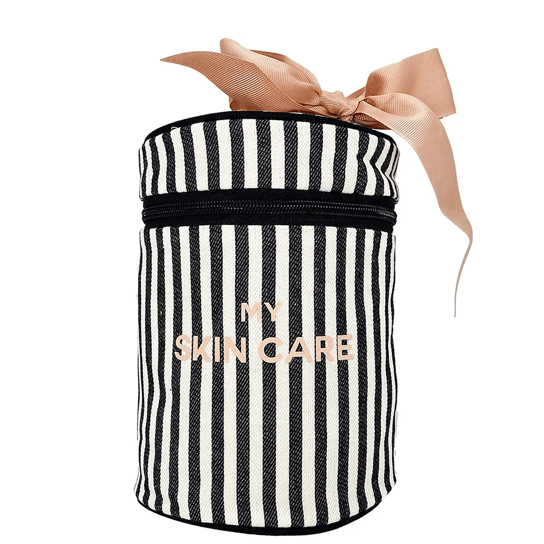 Bag-all Round Skin Care Case with Handle featuring black and white stripes, pink bow accent, zippered closure, perfect for organizing beauty essentials. Stylish cylindrical travel organizer with laminated interior.