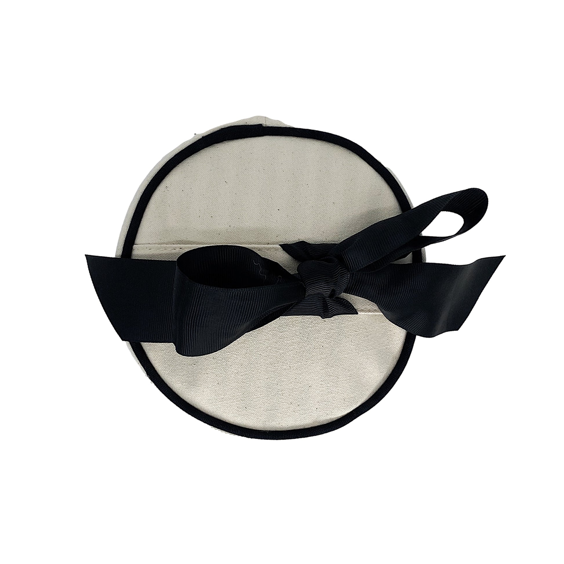 Bag-all Round Skin Care Case with Handle in cream canvas featuring black trim and elegant bow accent, top view of cylindrical travel organizer for beauty products