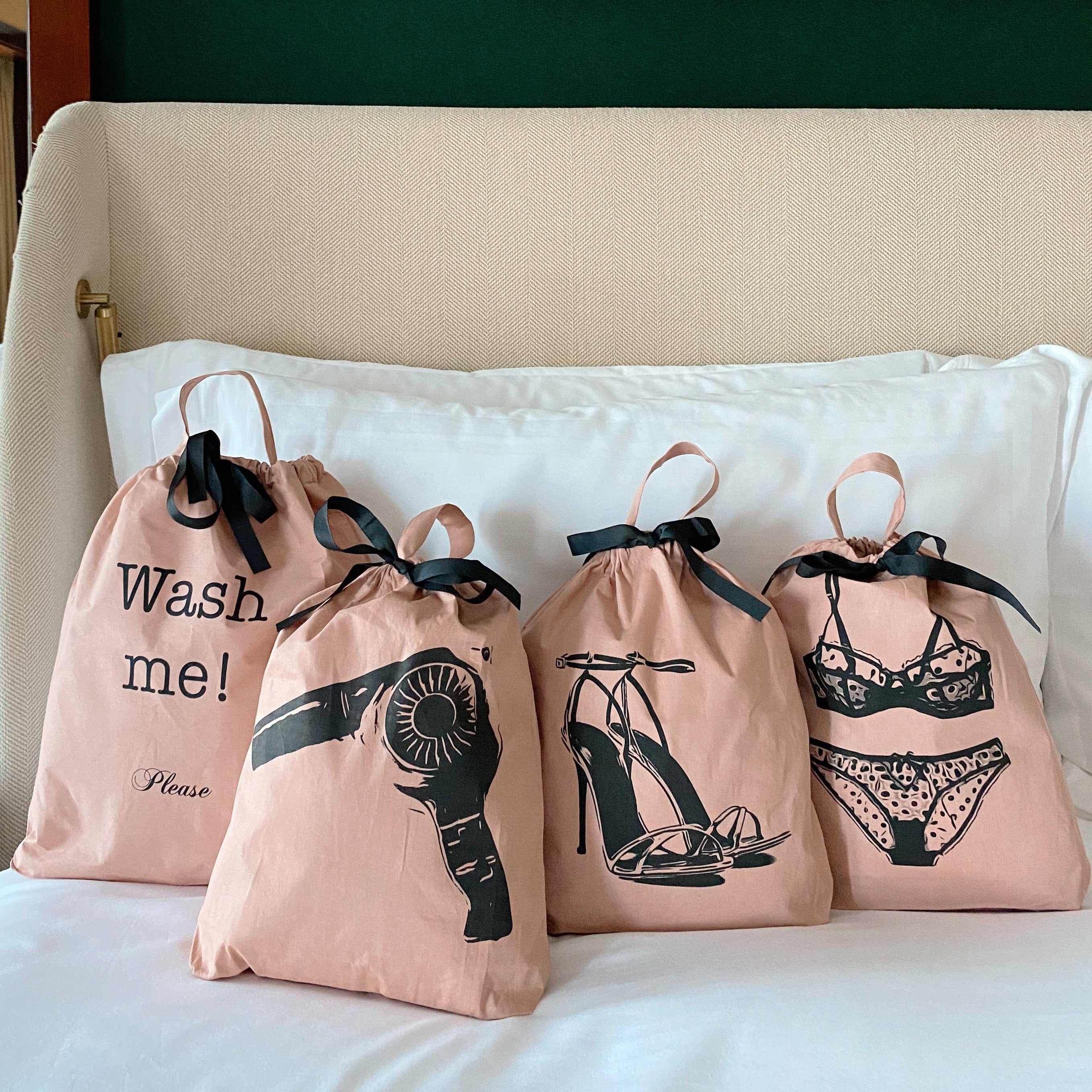 Bag-all Women's Travel Set 4-pack in Pink/Blush featuring organized storage bags for laundry, hair dryer, lingerie, and shoes, with black ribbon ties and stylish prints on light pink cotton fabric