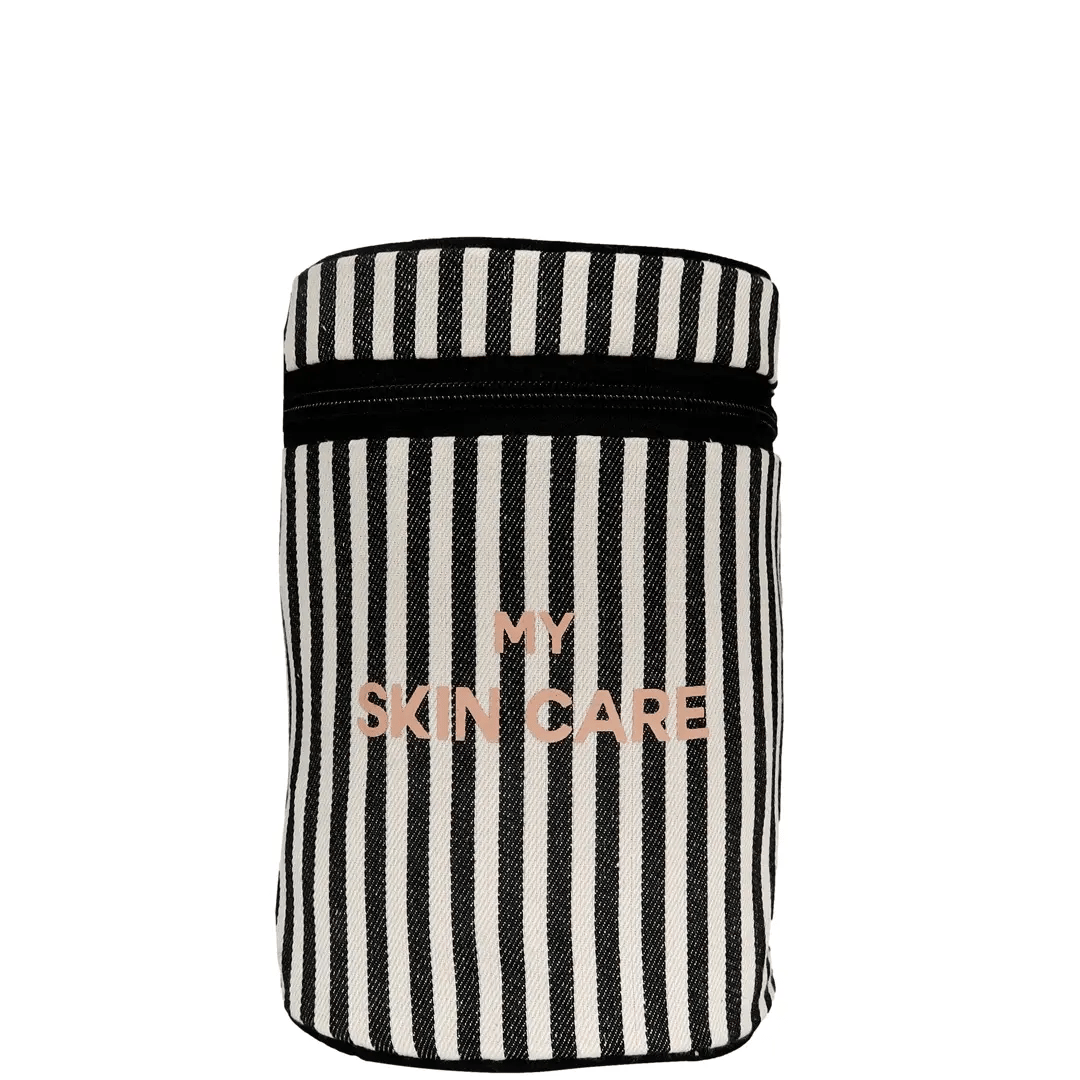 Bag-all Round My Skin Care Case in black and white stripes with rose gold lettering, featuring cylindrical design and zipper closure for skincare organization