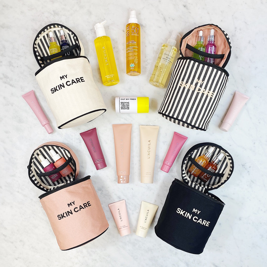 Bag-all Round Skin Care Case with Handle in pink, black, and white colors, displayed with various skincare products, showcasing organized storage and stylish striped interior lining