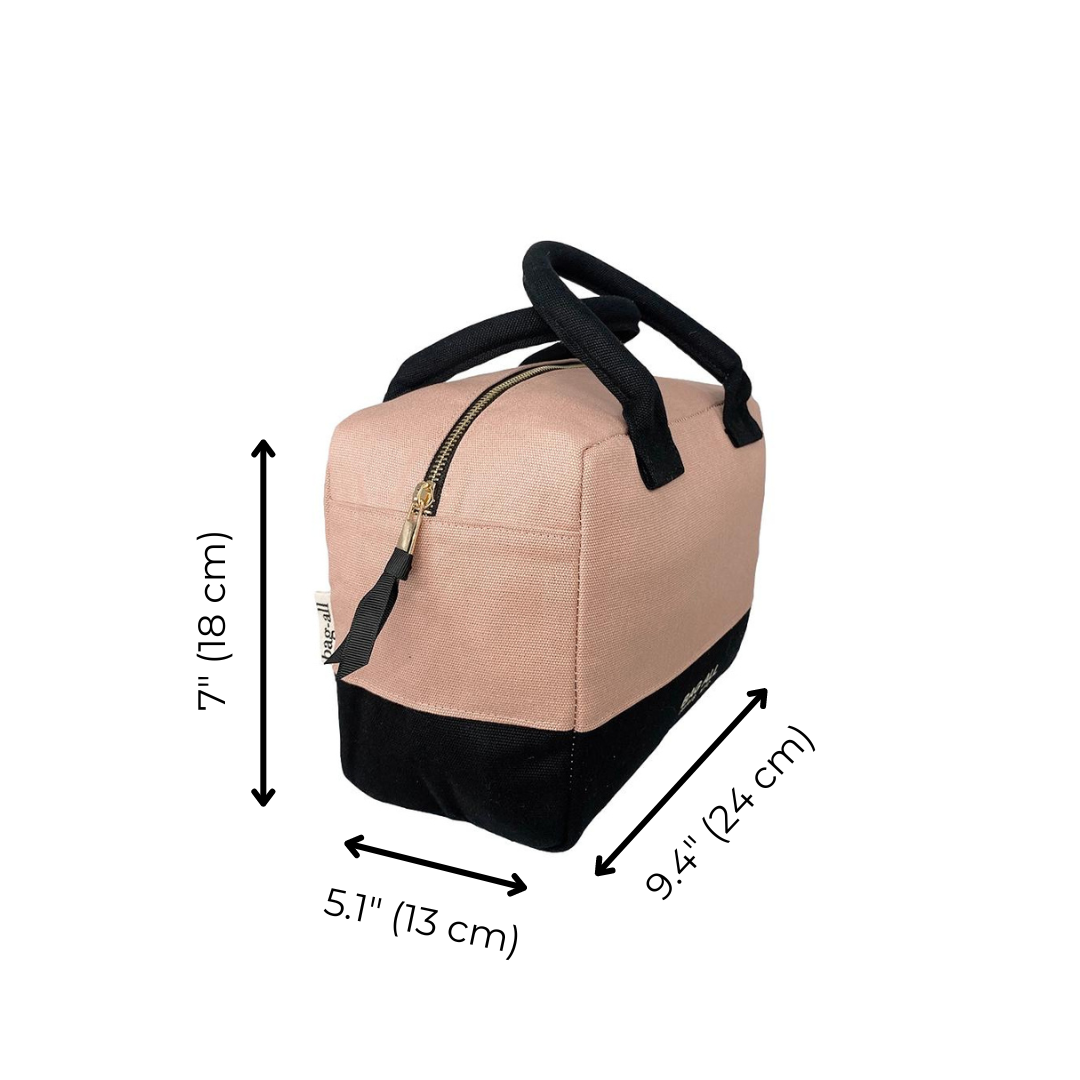 Bag-all Stylish Monogram Lunch Box in pink/blush with black trim, featuring insulated design, gold zipper, and padded handles. Dimensions shown: 7" height, 5.1" width, 9.4" depth