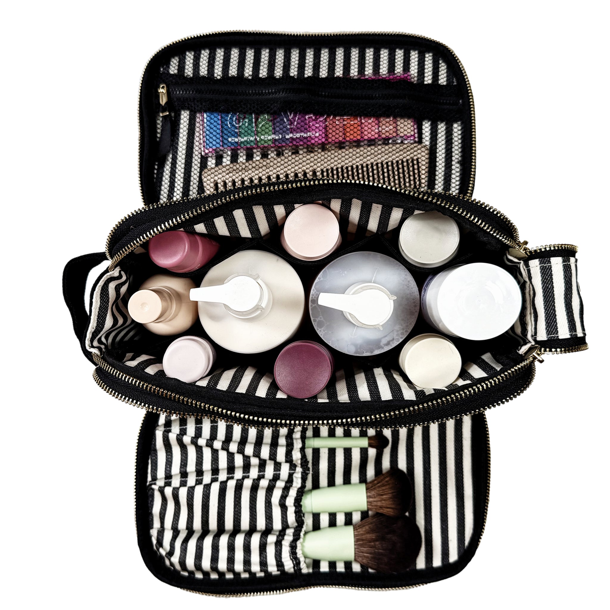 Open black and white striped Bag-all toiletry bag filled with cosmetic bottles and brushes on white background