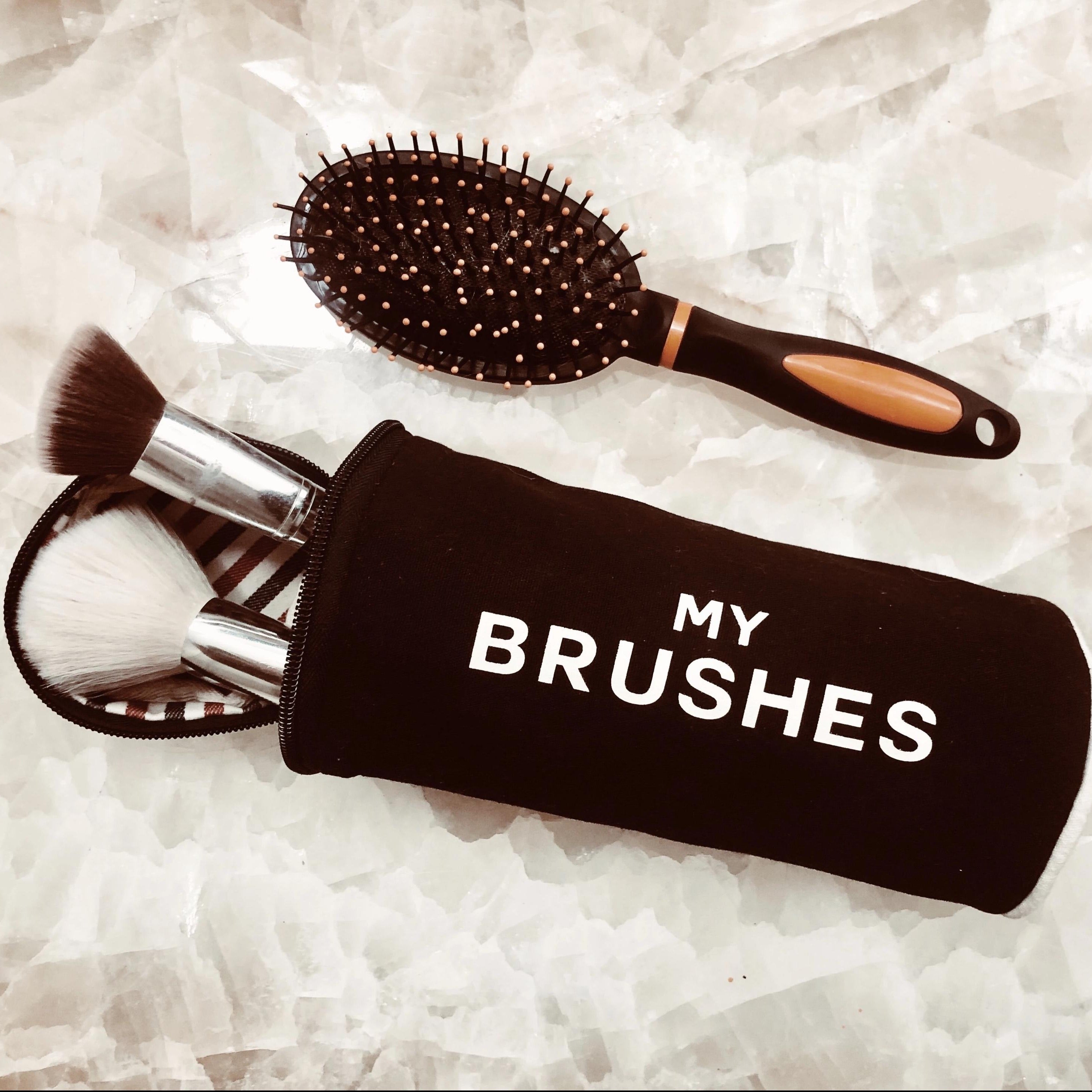 Black Bag-all hair tools organizer pouch with makeup brushes and a brush on a white background for easy storage