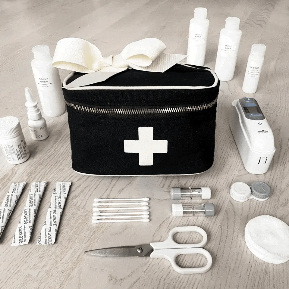 Bag-all Black First Aid Storage Box with white cross design, shown with medical supplies, featuring dual zippers and handle for portable organization