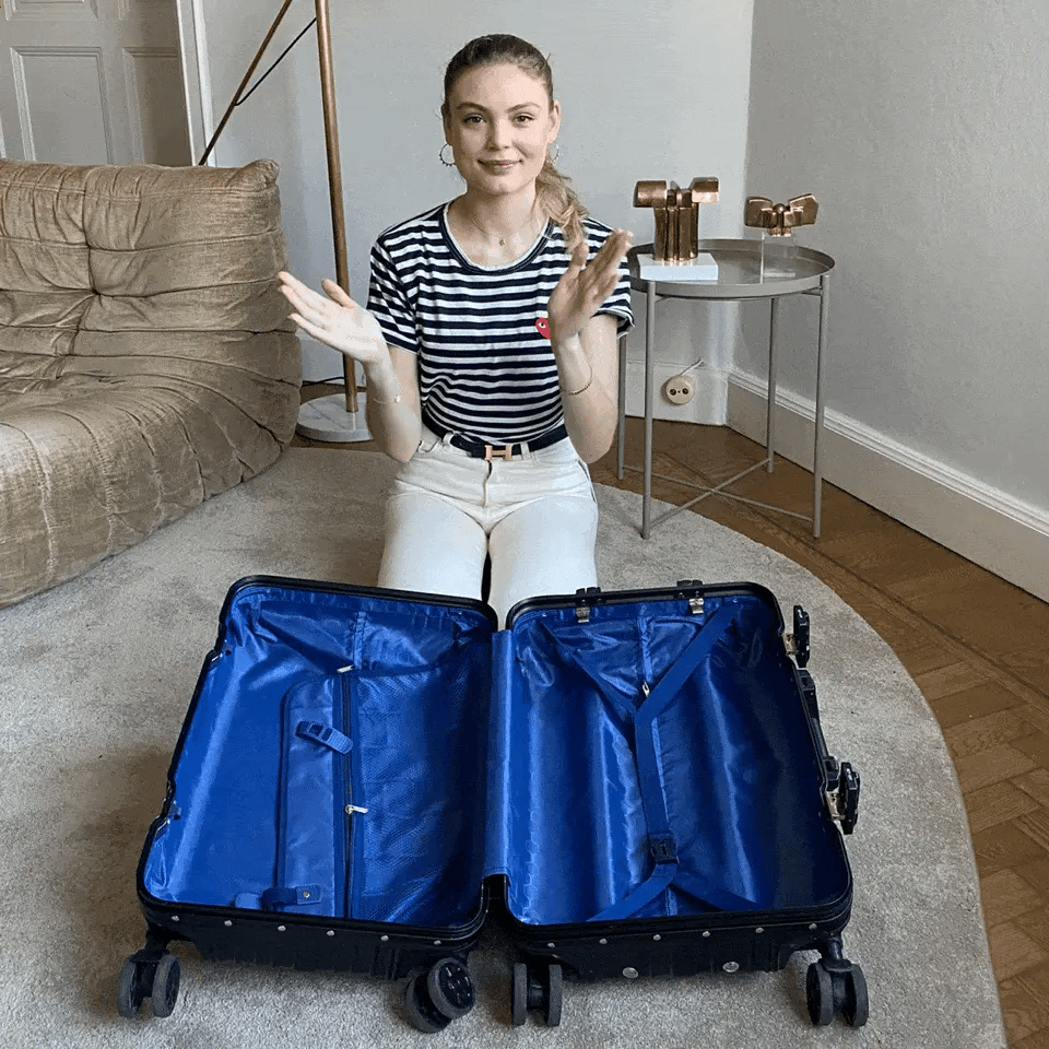 Bag-all stylish rolling suitcase with bright blue interior lining, displayed open on floor with smooth spinning wheels and spacious compartments for organized travel