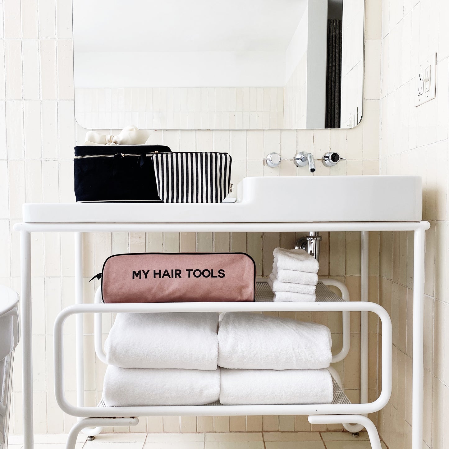 Bag-all Medium Box Makeup & Toiletry in black cotton with striped interior, shown in modern bathroom setting with hair tools case and white towels, perfect for stylish organization
