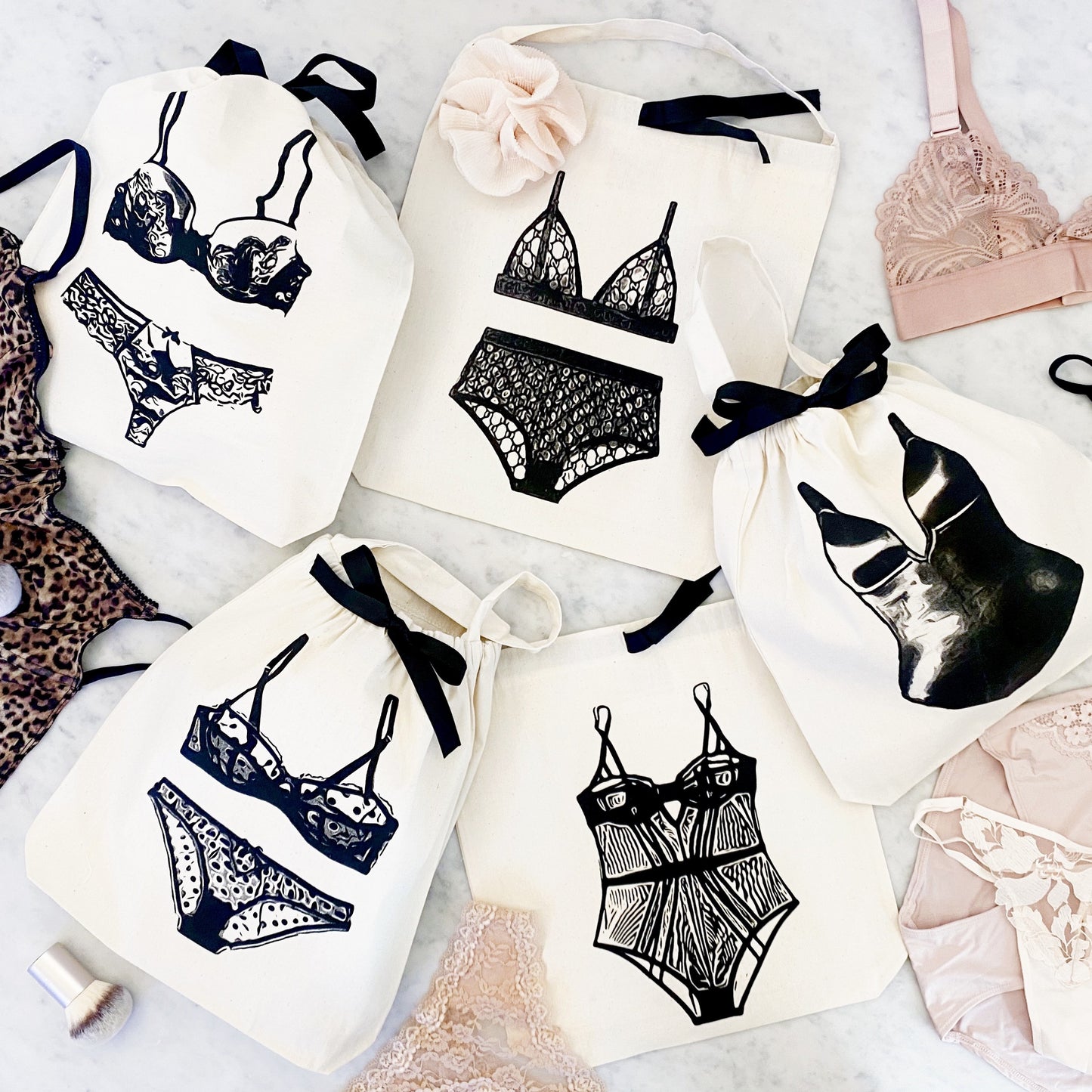 Bag-all Shapewear Travel Bag in Cream featuring stylish lingerie illustrations, black ribbon ties, organized storage solution for delicate undergarments and shapewear pieces