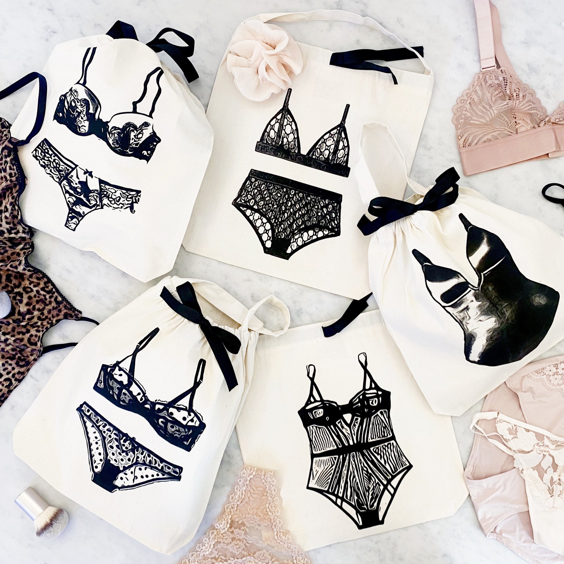 Bag-all Shapewear Travel Bag in Cream featuring stylish lingerie illustrations, black ribbon ties, organized storage solution for delicate undergarments and shapewear pieces
