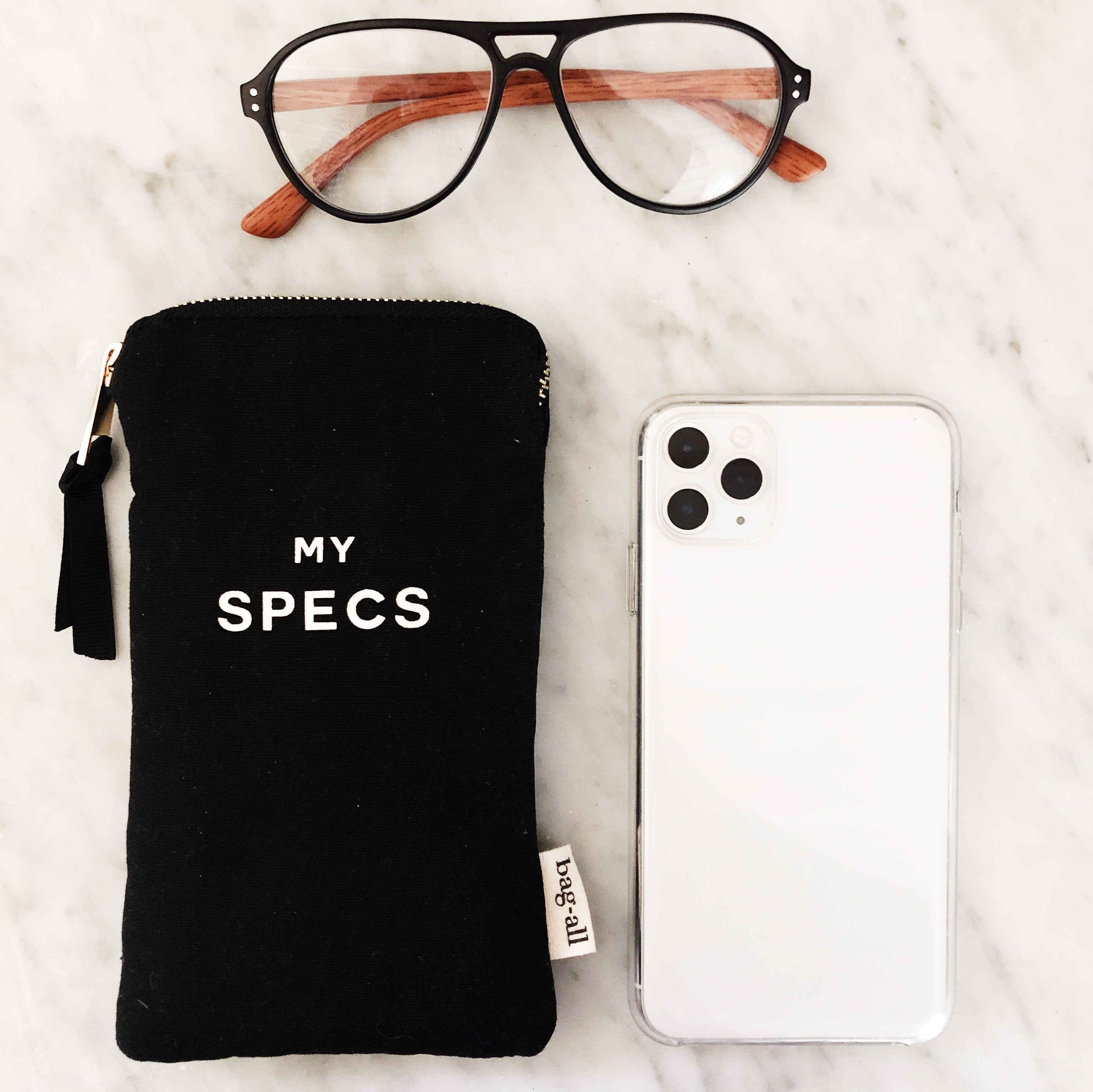 Bag-all My Specs Glasses Case with Outside Pocket in black canvas, featuring white text, shown with aviator glasses and smartphone, perfect for protecting eyewear and accessories
