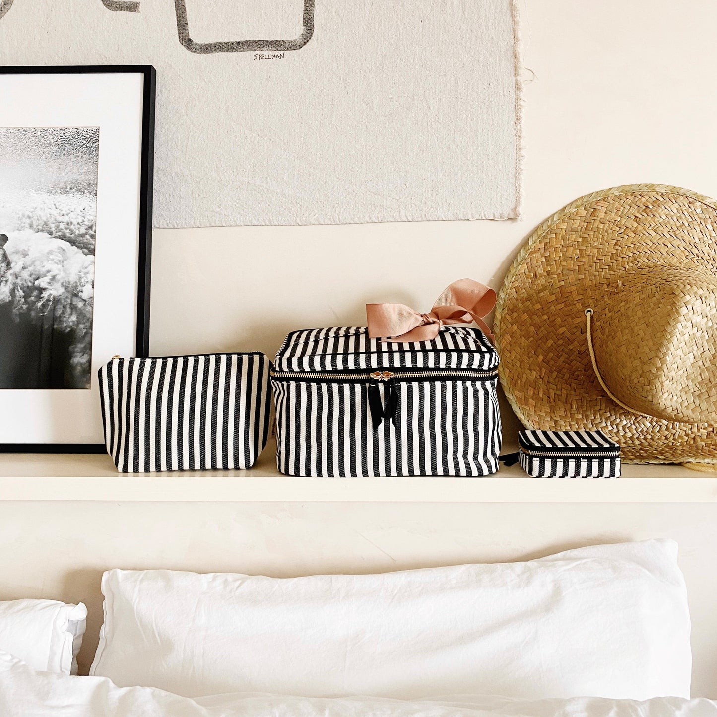 Bag-all Cutest Striped Travel Gift Set 3-Pack featuring black and white striped cotton makeup bag, toiletry case and pill organizer displayed on white shelf with straw hat