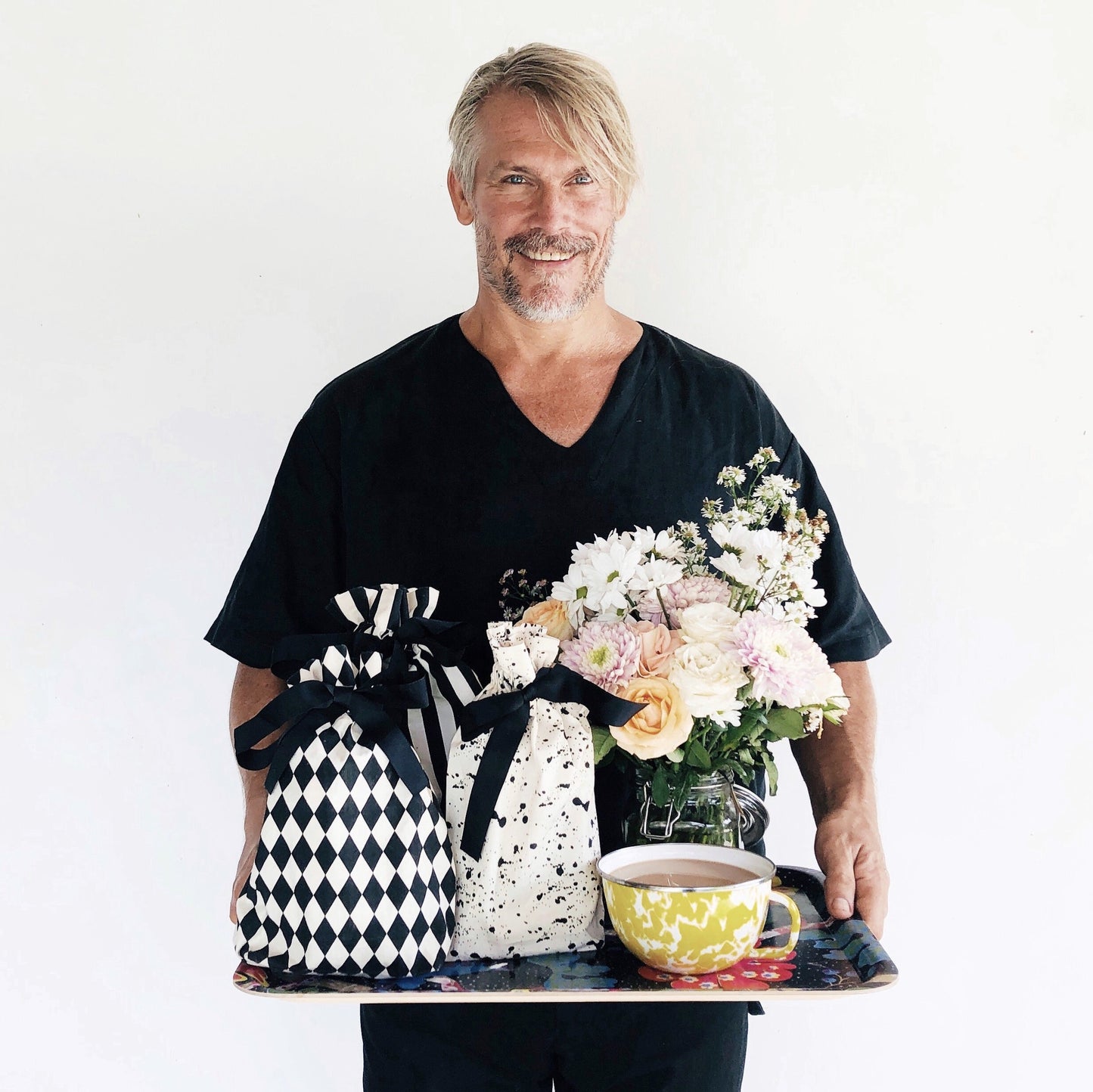 Bag-all Gift Bag Splatter Small eco-friendly reusable fabric bag shown with black and white diamond pattern and splatter design, displayed alongside fresh flowers and tea cup