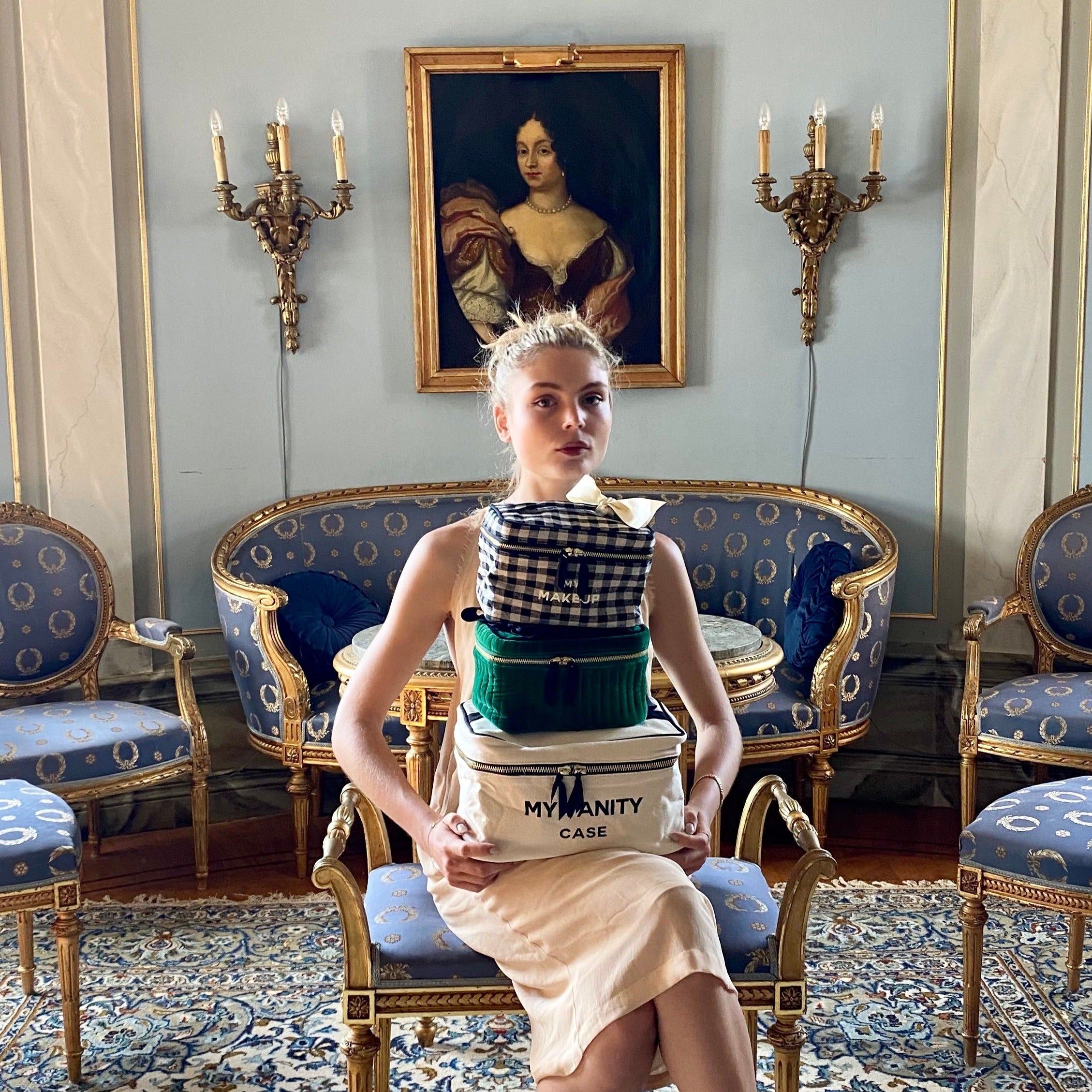 Bag-all My Vanity Large Beauty Box in cream, stacked with organizers and toiletries, displayed in an elegant vintage room with blue upholstered furniture and classical decor