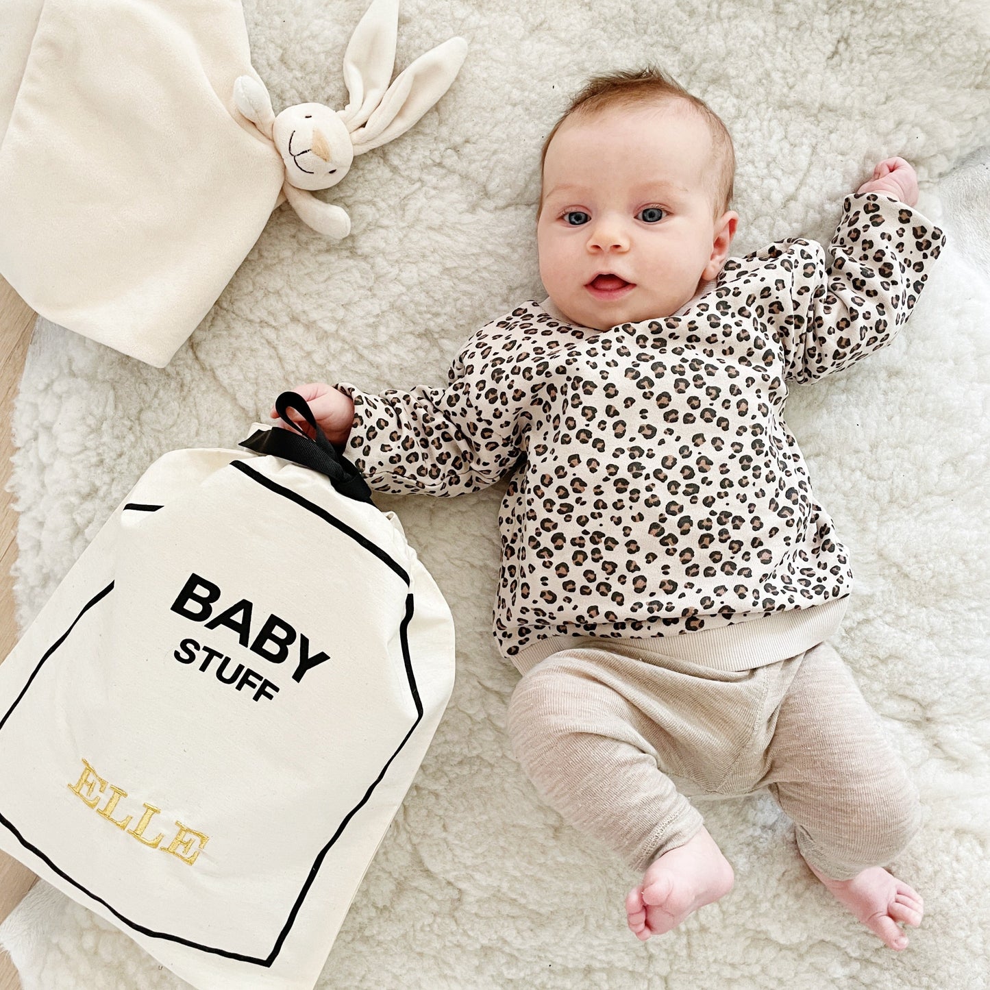 Bag-all Baby Stuff travel bag featuring soft cotton organizer, shown with infant in leopard print top, perfect for storing baby essentials in style