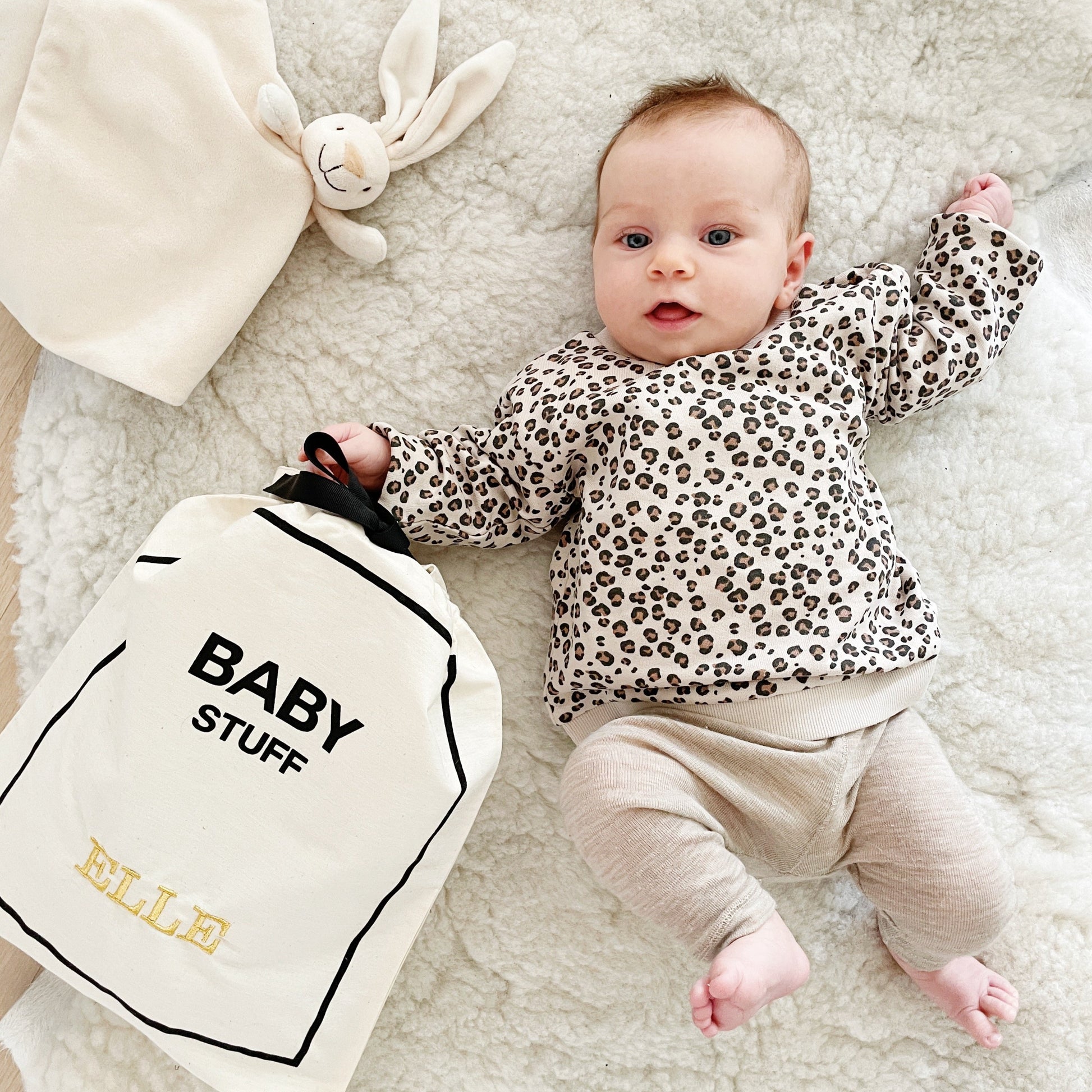 Bag-all Baby Stuff travel bag featuring soft cotton organizer, shown with infant in leopard print top, perfect for storing baby essentials in style