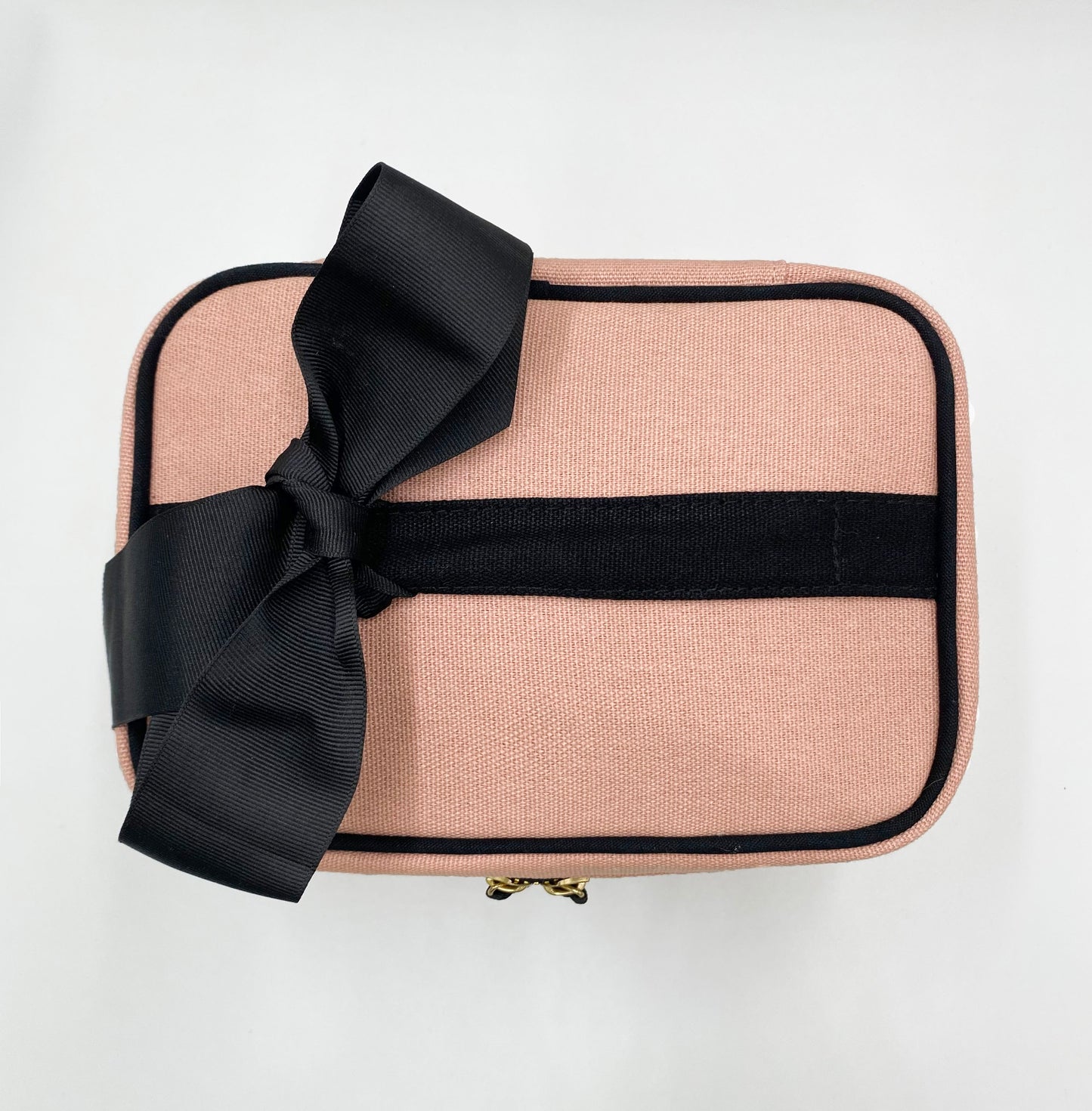 Bag-all My Makeup Cosmetic Box in blush pink with black bow accent, black piping, and gold zipper pulls - stylish organizer case with laminated interior for makeup storage