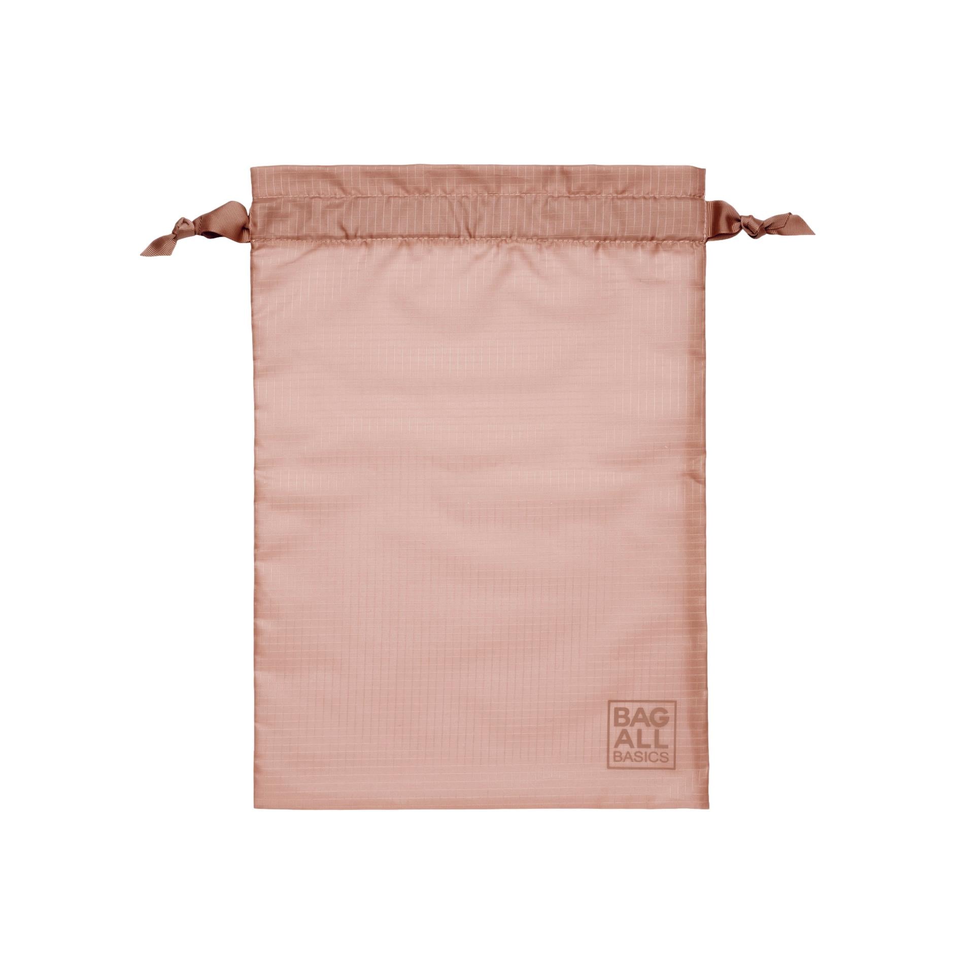 Bag-all recycled nylon packing bag in blush pink with drawstring closure, featuring eco-friendly construction and brand logo imprint at bottom corner