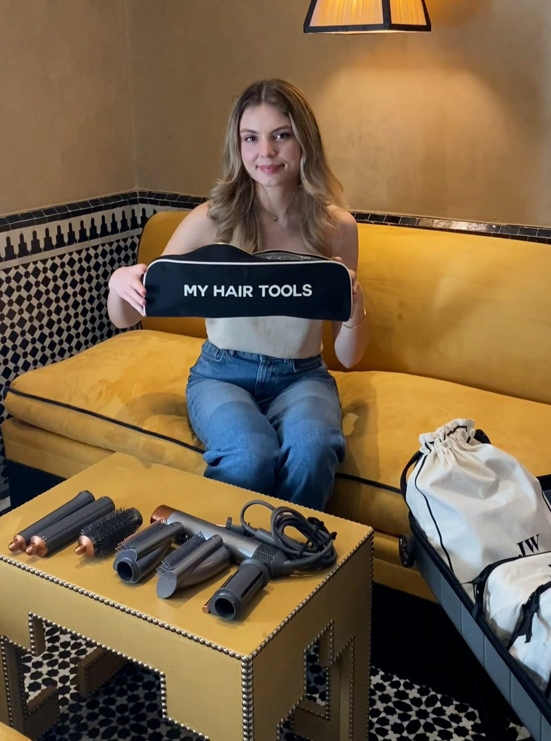 Bag-all Roomy Hair Wrap Tools Travel Case displayed with Dyson Airwrap attachments and styling tools on decorative gold table, black case features "My Hair Tools" text and heat-resistant lining