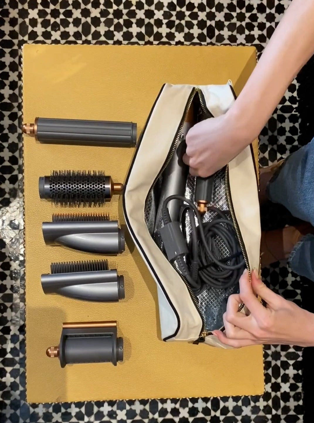 Bag-all Roomy Hair Wrap Tools Travel Case in cream color with heat-resistant lining, shown with Dyson Airwrap attachments and styling tools arranged neatly beside organized storage compartment