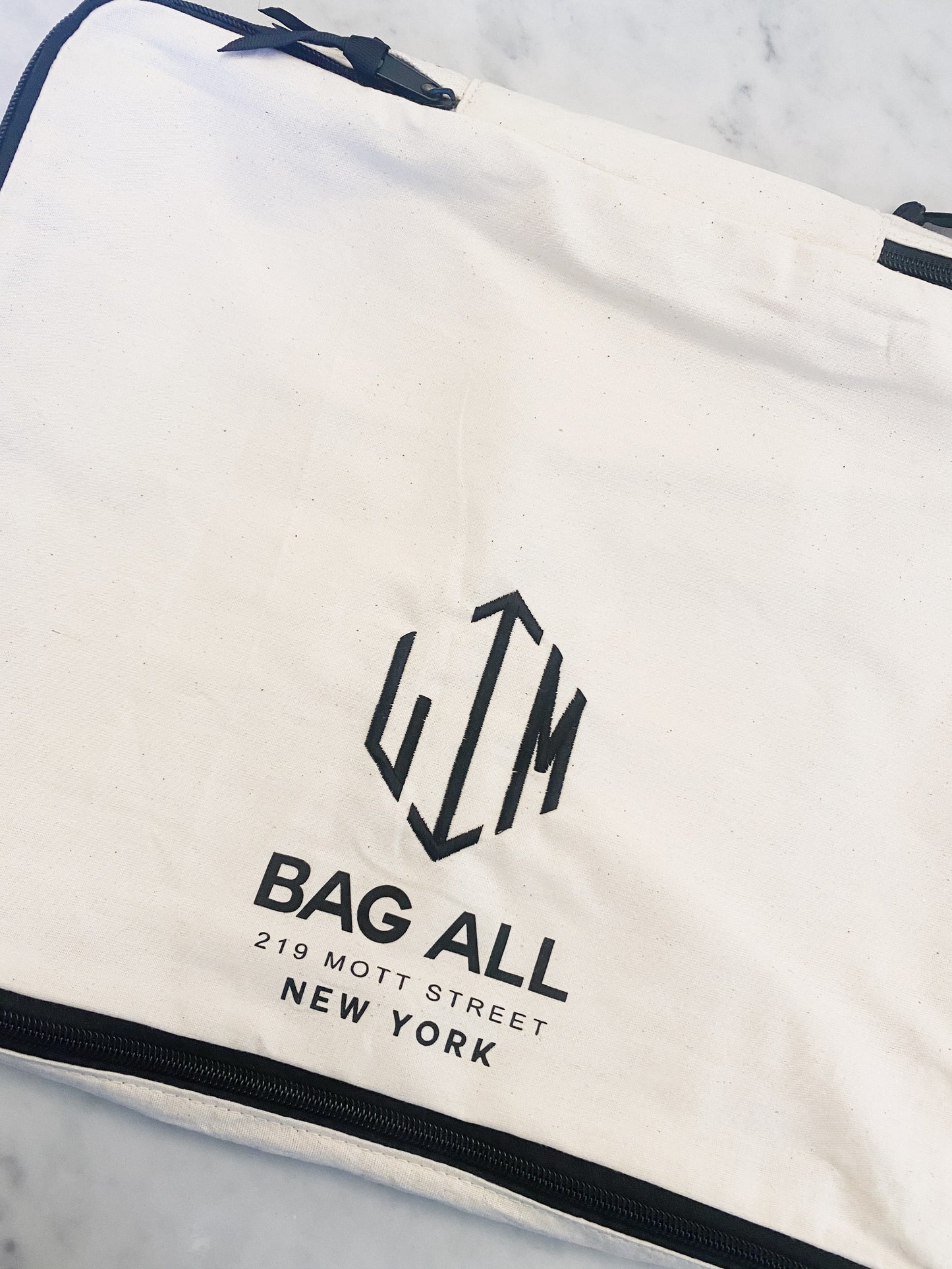 Bag-all Large Packing Cube Double Sided in cream with black logo detail and zipper closure, featuring the iconic Bag-all New York branding and double compartment design