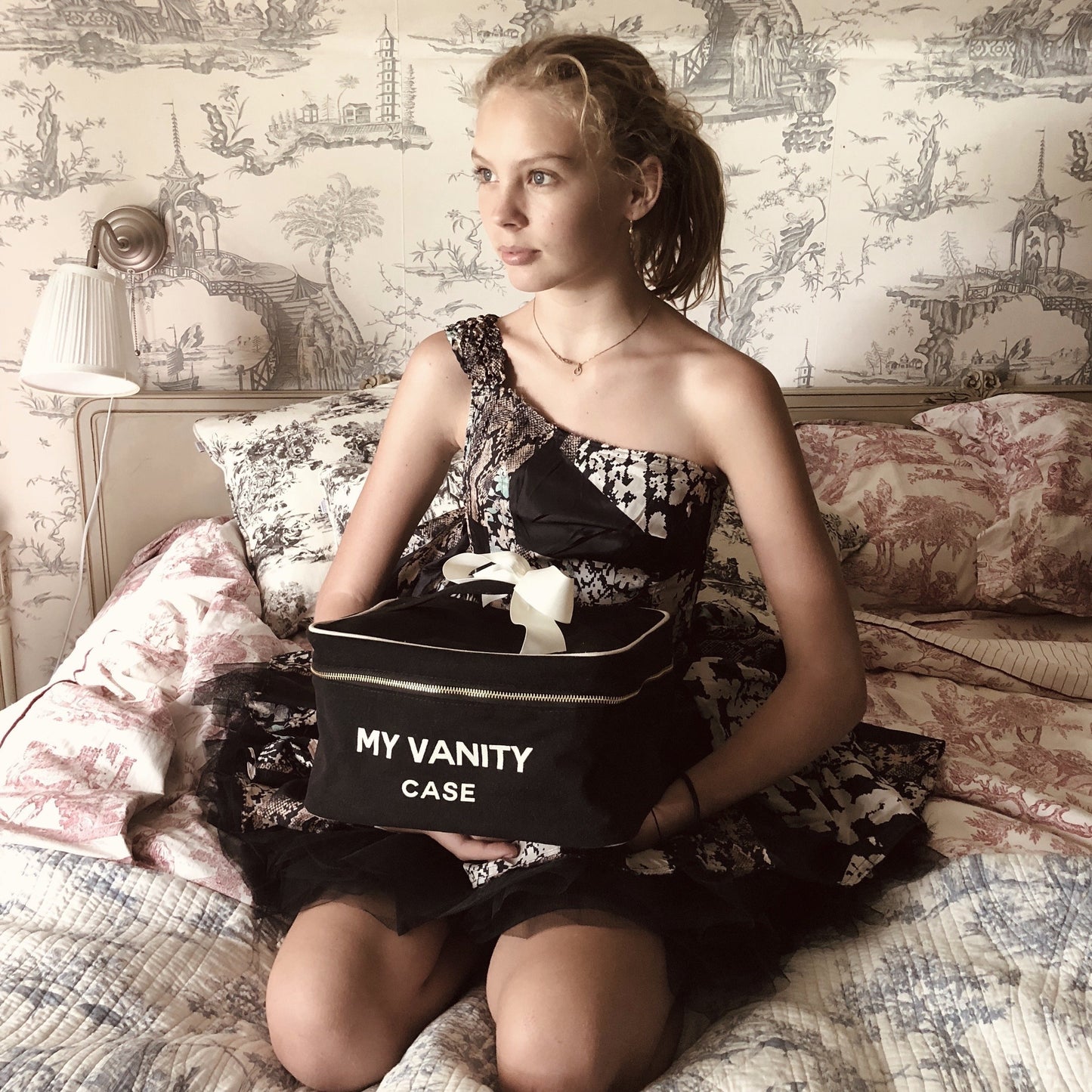 Bag-all My Vanity Large Beauty Box in classic black, featuring elegant white text and bow detail, shown in vintage-inspired toile setting with striped waterproof lining for cosmetics storage