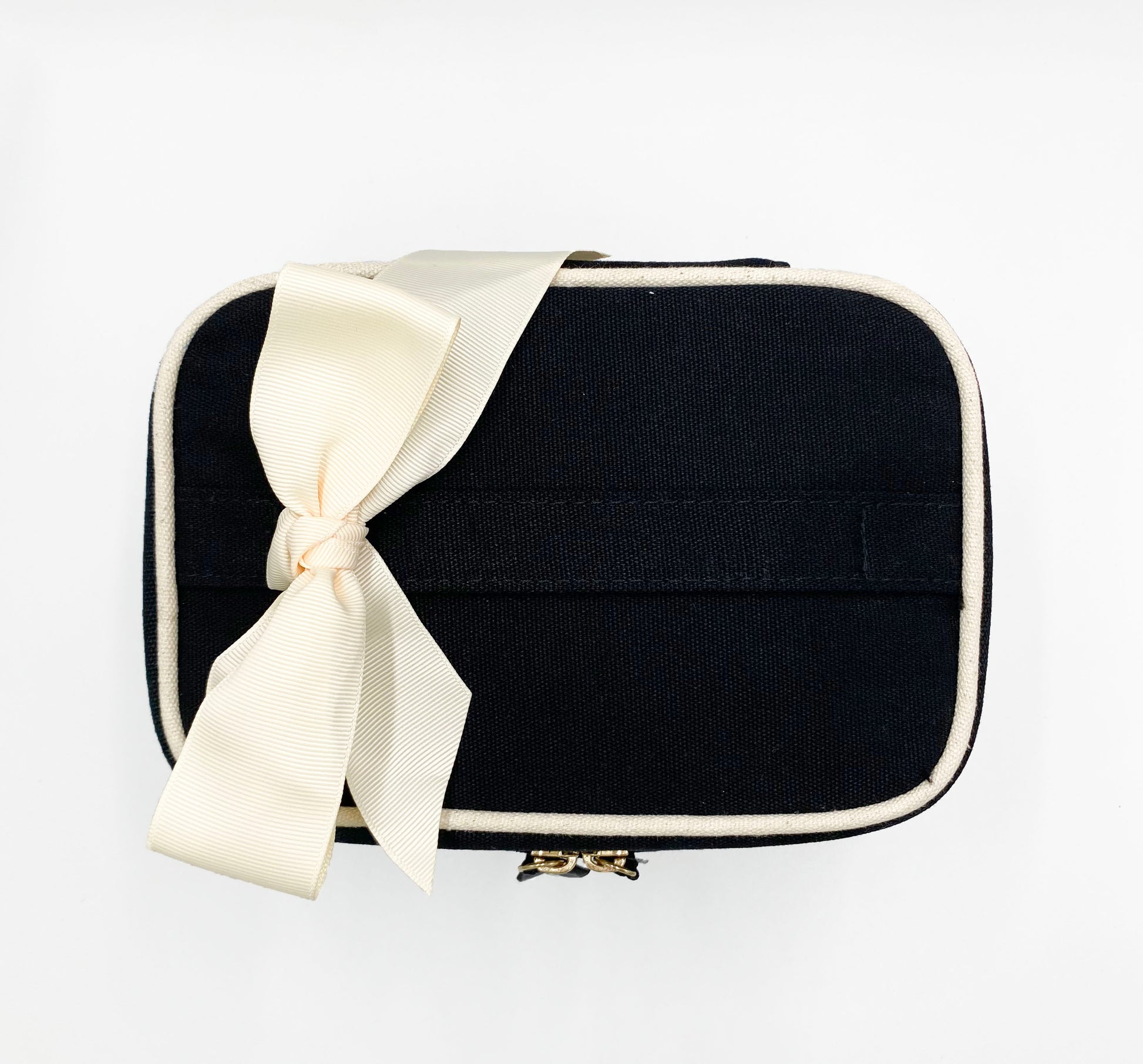 Bag-all Meds and First Aid Storage Box in black canvas with cream ribbon, dual metal zippers and medical cross print. Portable organizer for medications and first aid supplies.