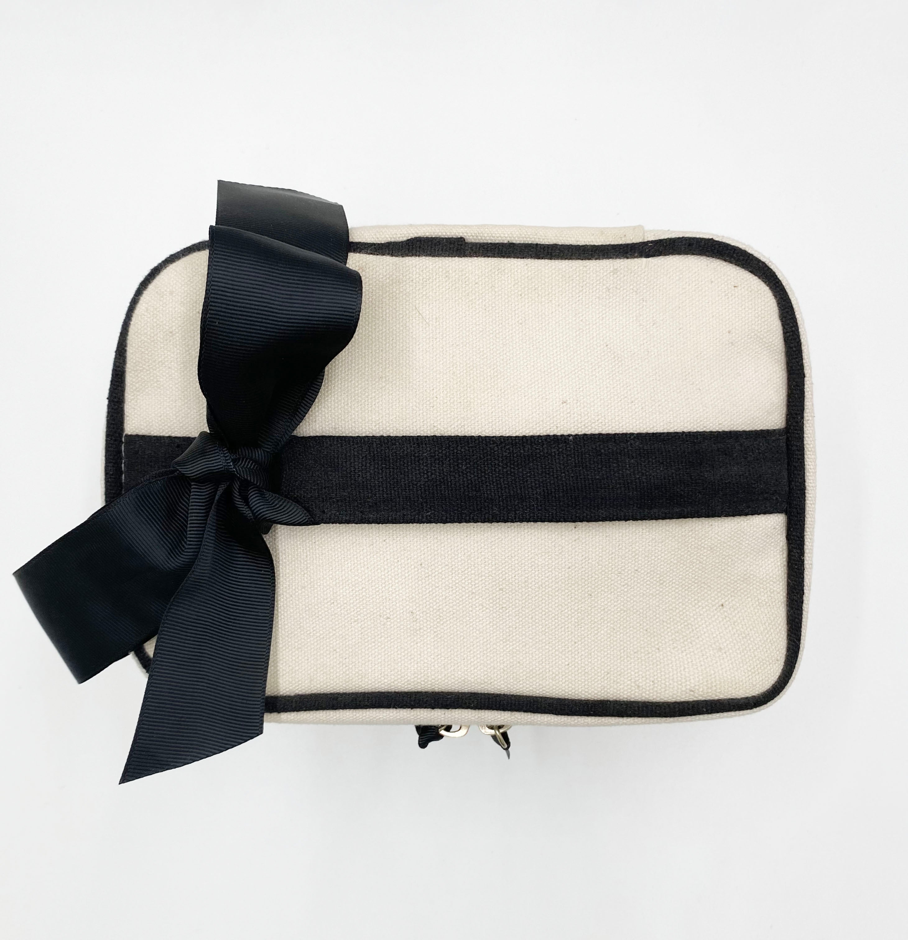 Bag-all My Makeup Cosmetic Box in cream canvas with black trim and elegant bow detail, waterproof interior perfect for beauty essentials and travel organization