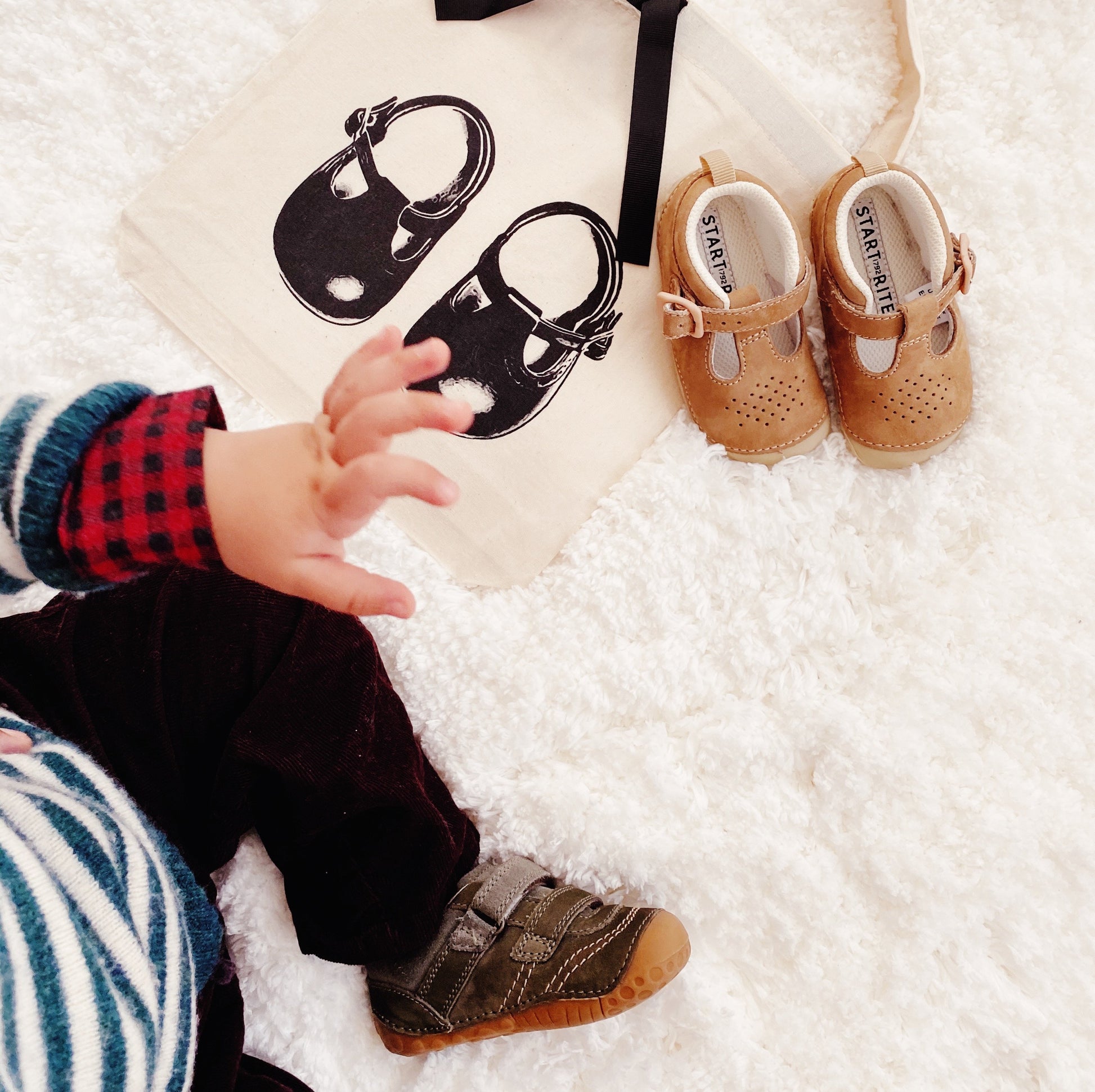 Bag-all organizing shoe bag featuring cute baby shoes and small hand, perfect for storing children's footwear and keeping pairs together