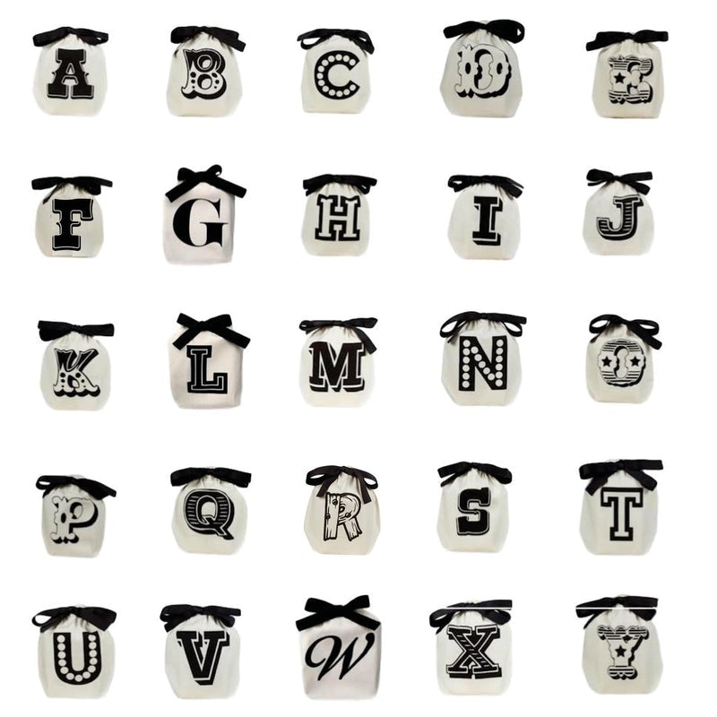 Bag-all Small Letter Bags Mix in cream featuring complete alphabet set with black bows, perfect for organizing small items. Each bag displays a decorative uppercase letter in black on white cotton.