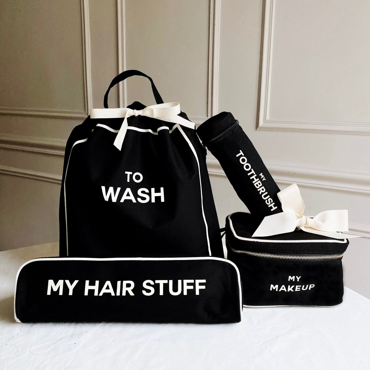 Bag-all Deal Gift Set featuring black cotton travel organizers - To Wash laundry bag, Hair Stuff case, Toothbrush holder, and Makeup box with white trim and text