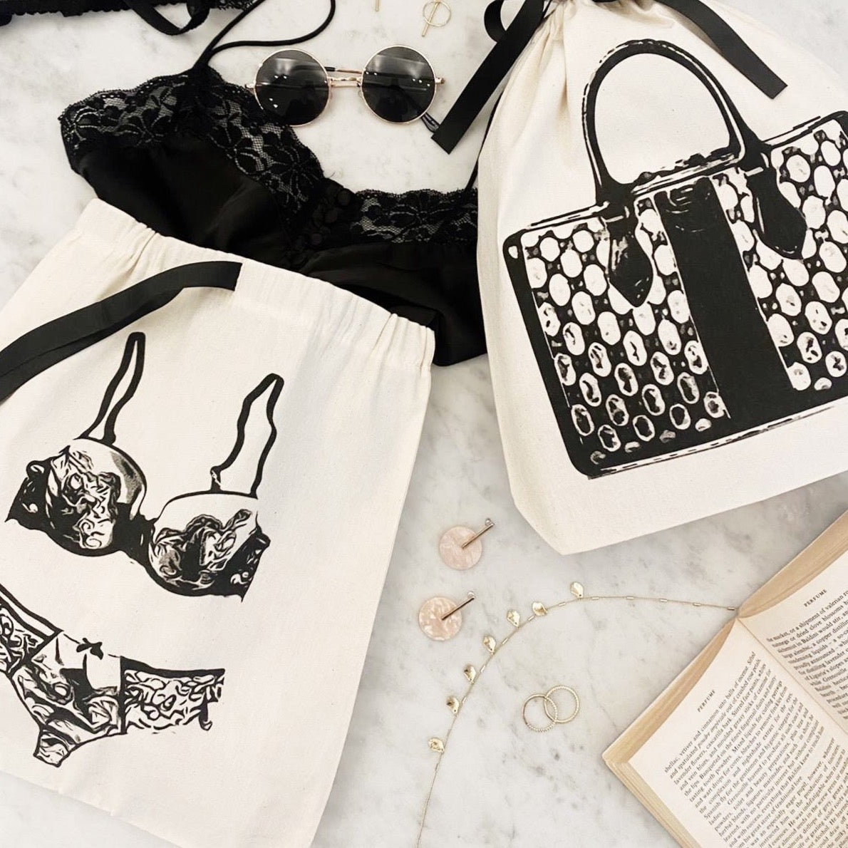 Bag-all Lace Lingerie Travel Bag in cream cotton with black lingerie illustration, perfect for organizing delicates while traveling. Features drawstring closure and classic monochrome design.
