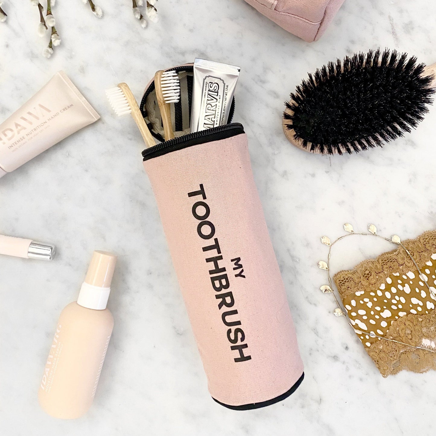 Bag-all pink blush My Toothbrush travel organizer pouch with brushes and toothpaste on marble with beauty essentials