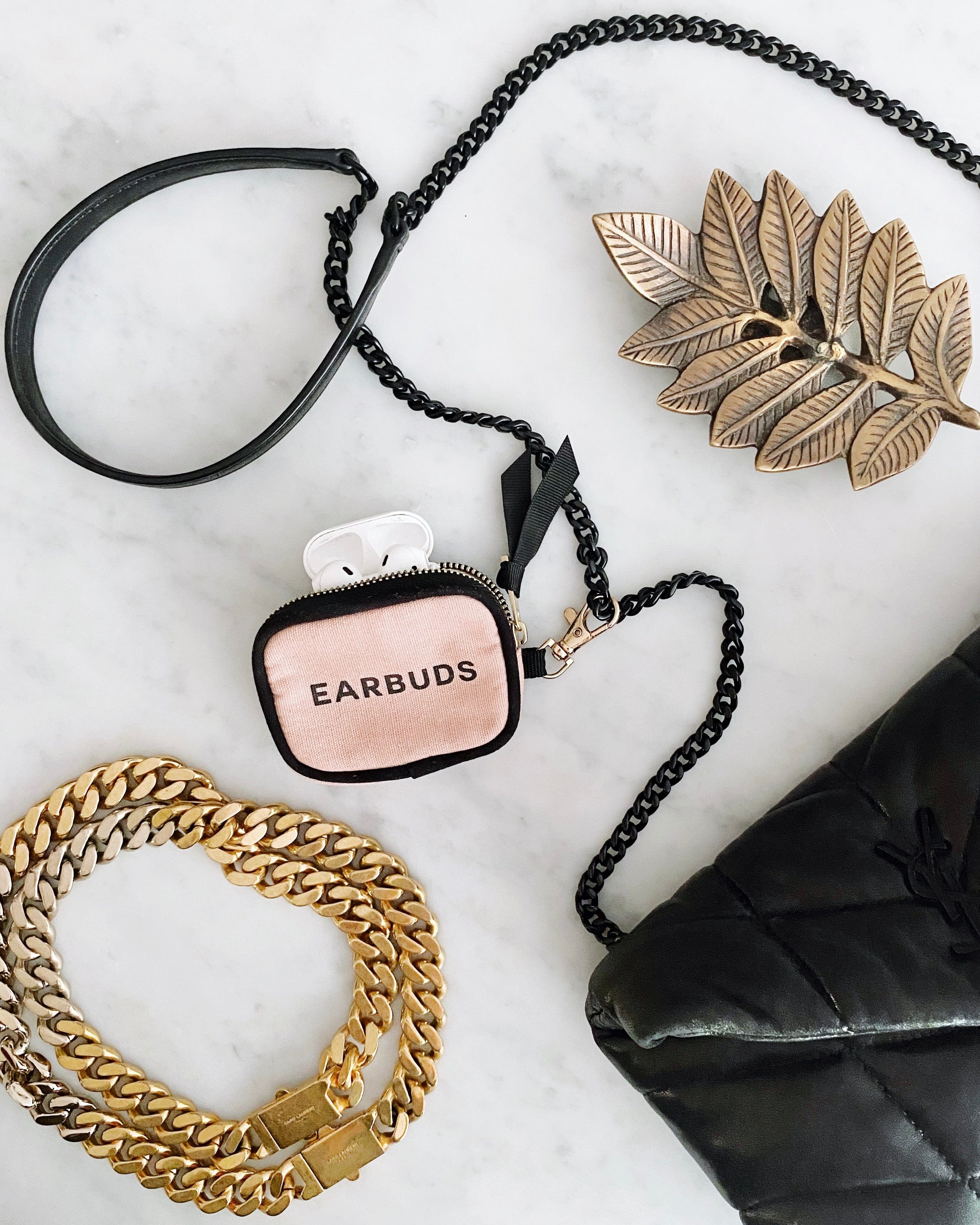 Bag-all Handbag Organizer Trio featuring pink earbud case with black chain strap, displayed with gold leaf decor and chunky chain accessories on marble surface