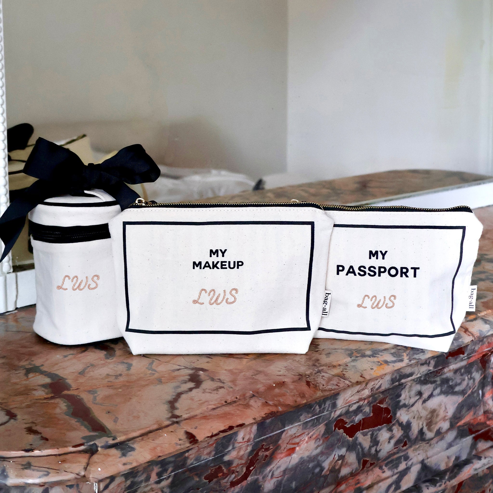 Bag-all cream 3-pack Carry On Essentials set with passport, liquid, and makeup organizers on marble surface