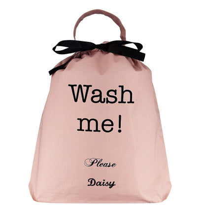 Bag-all Ultimate Gift Set featuring pink cotton laundry bag with 'Wash me!' text, black bow accent, and personalized name detail - part of 4-piece travel and home organizer collection