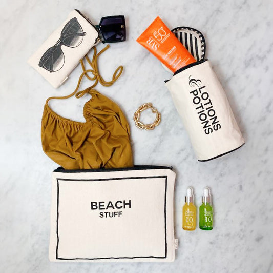 Bag-all Stylish Beach Essential Set in cream - 3 waterproof organizer bags with Beach Stuff pouch, sunglasses case, and toiletry holder arranged with summer accessories on marble surface