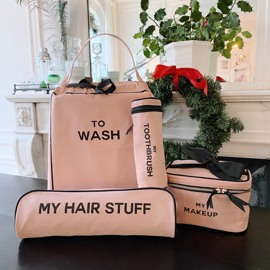 Pink Bag-all travel set with labeled toiletry bags for wash, toothbrush, hair stuff, and makeup on black table
