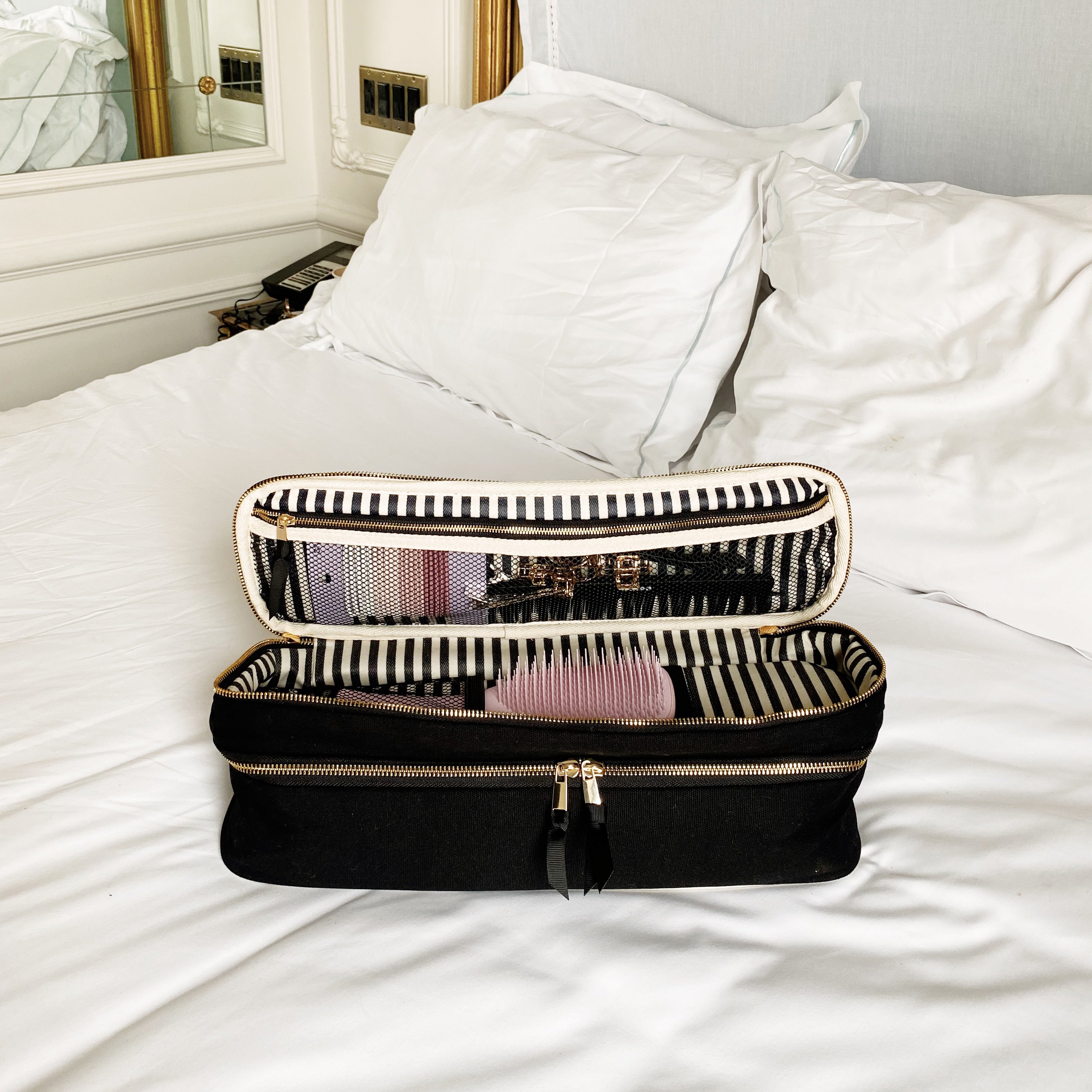 The Weekender Gift Set 3-pack black laundry and beauty case by Bag-all open on white bed with mirror reflection