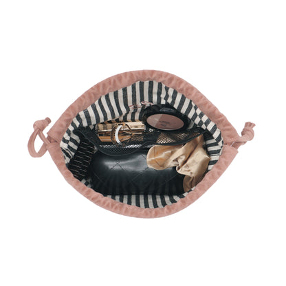 Open pink velvet drawstring makeup bag with striped lining holding cosmetics by Bag-all